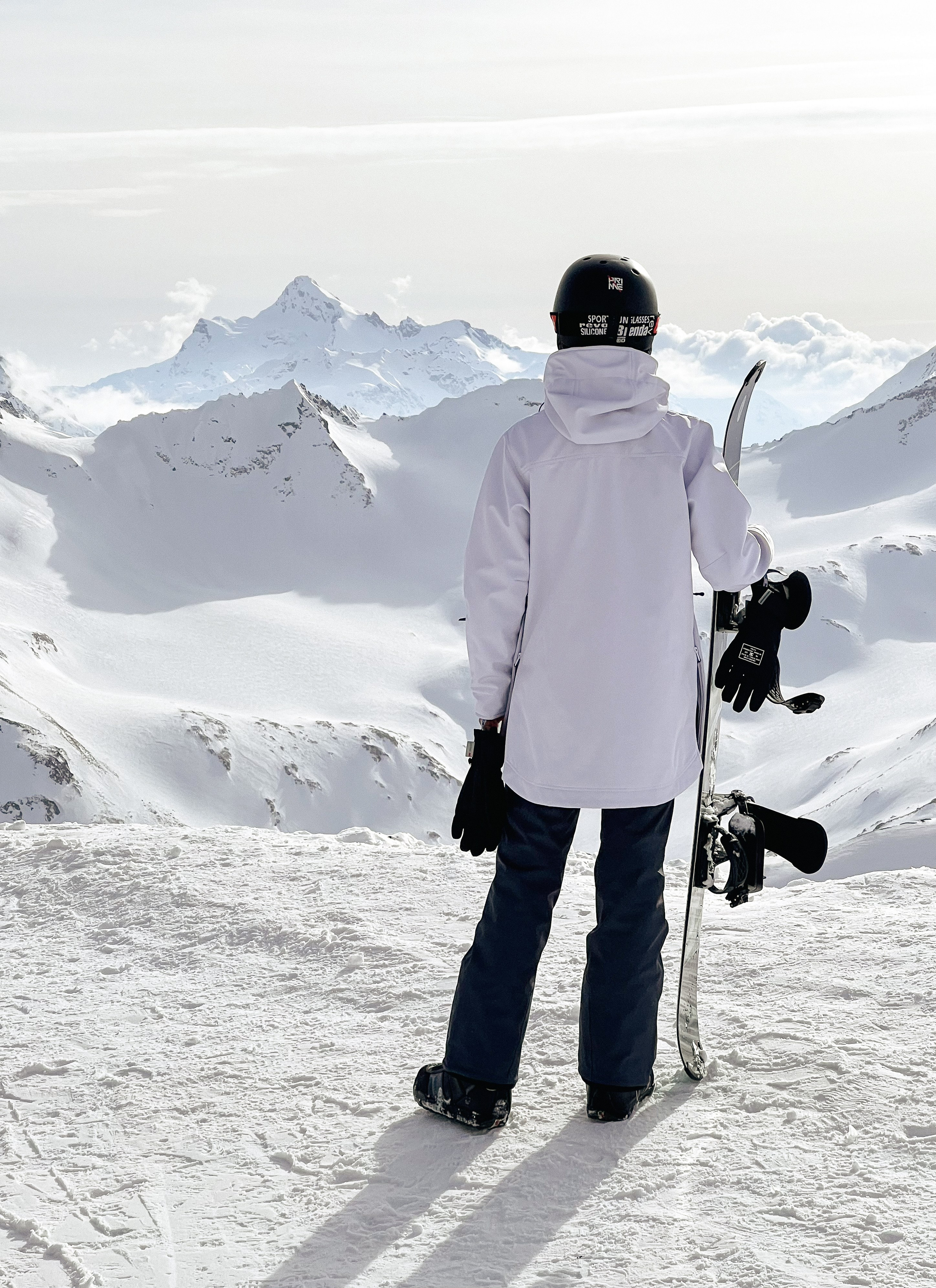 Сноубордист на склоне Эльбруса с видом на горные вершины зимой