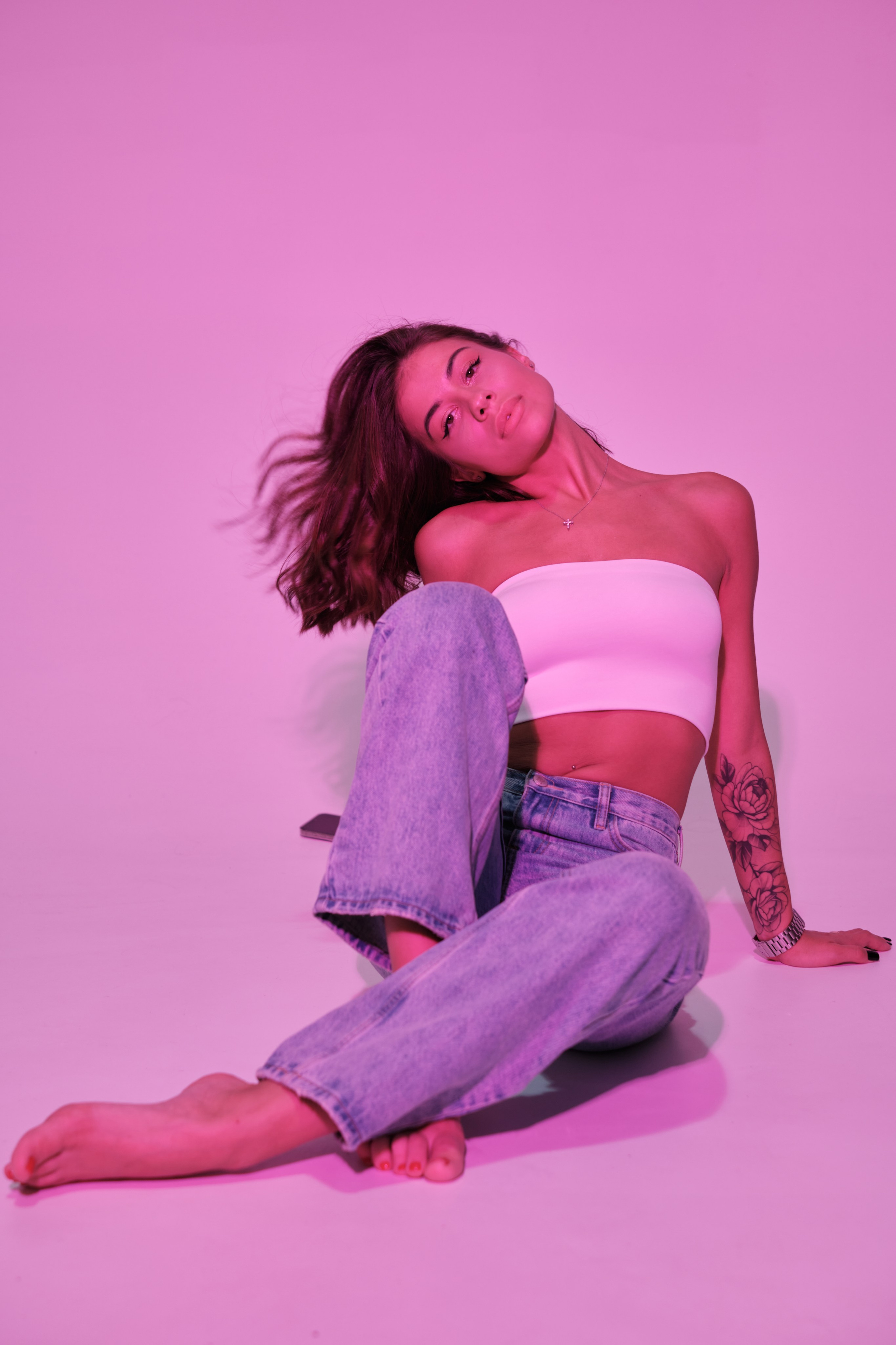 Сьемка в студии для модельного агентства, девушка в джинсах и белом топе, розовый свет