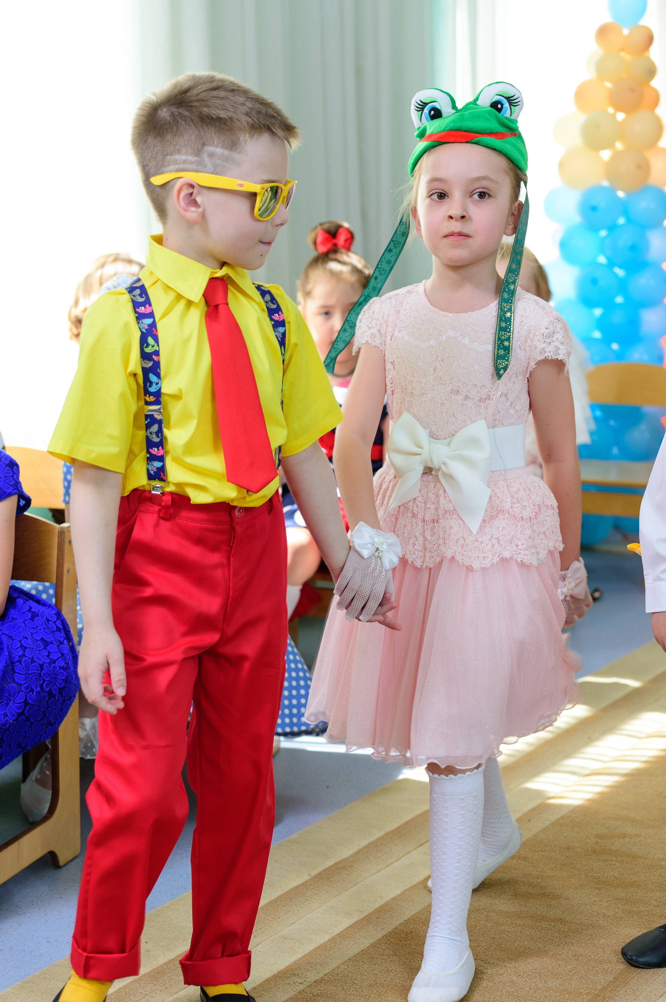 Мальчик и девочка идут, взявшись за руки.