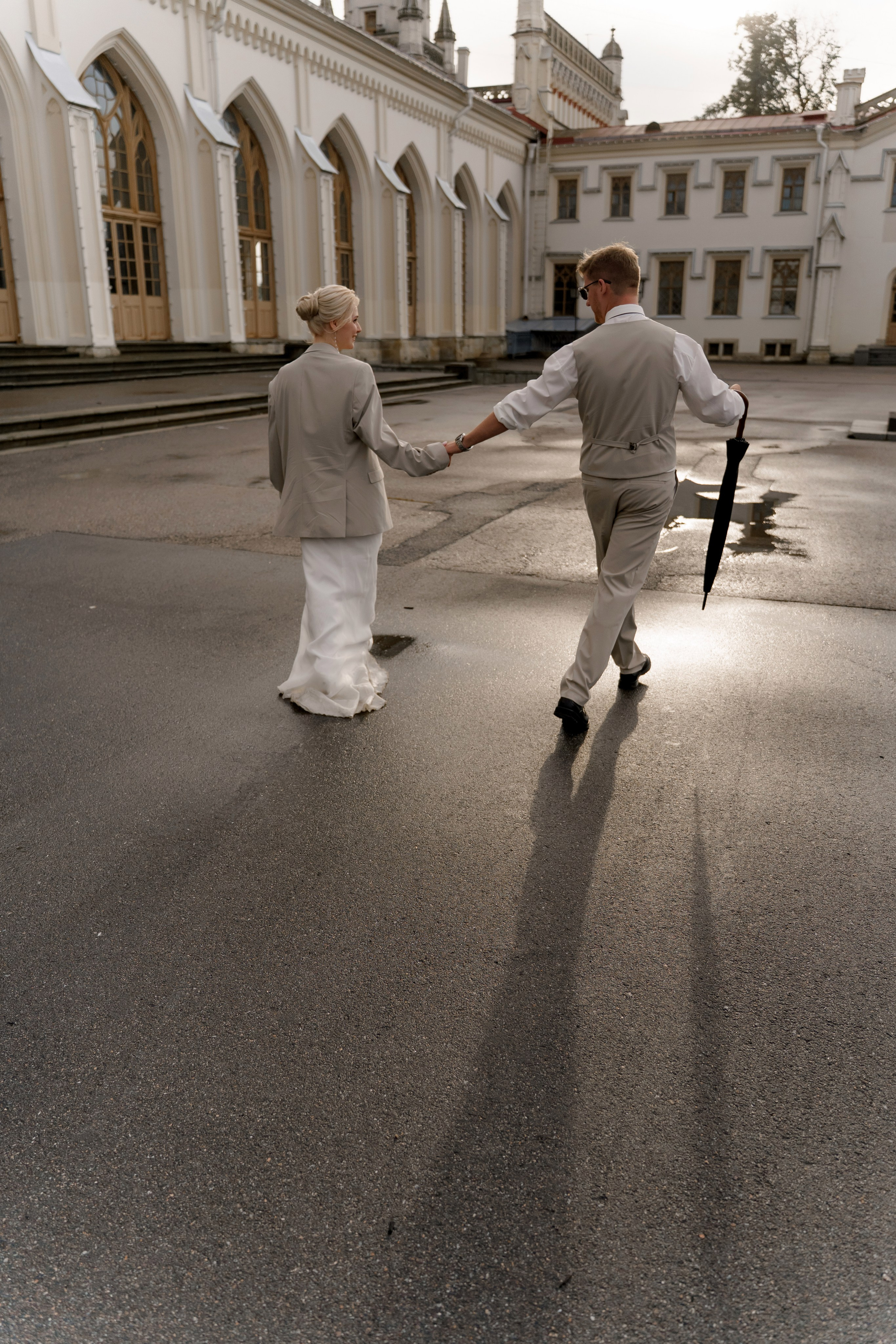 Свадьба в Санкт-Петербурге, фотосессия на прогулке, жених и невеста уходят на закате на фоне вокзала в Павловске.