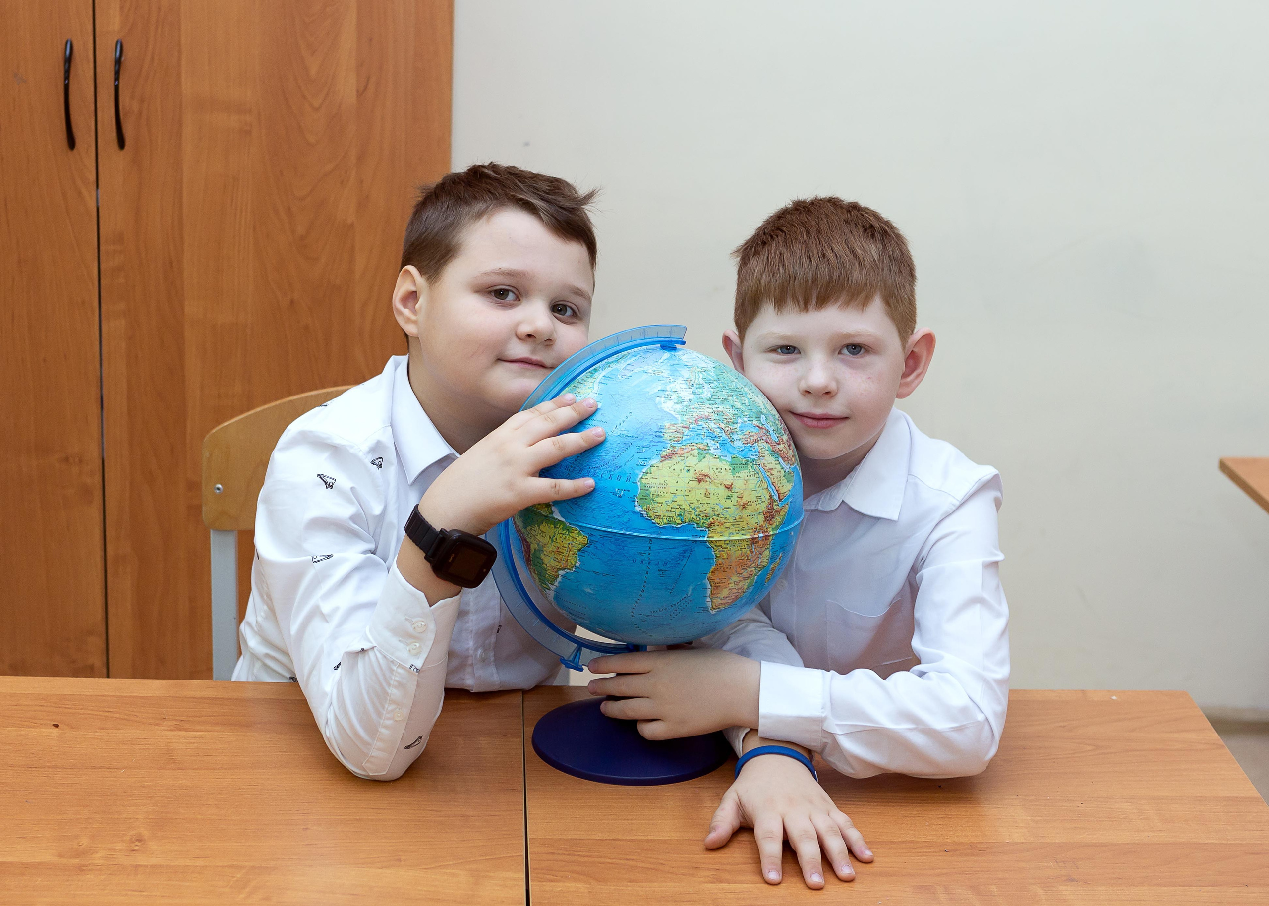 Мальчики изучает глобус