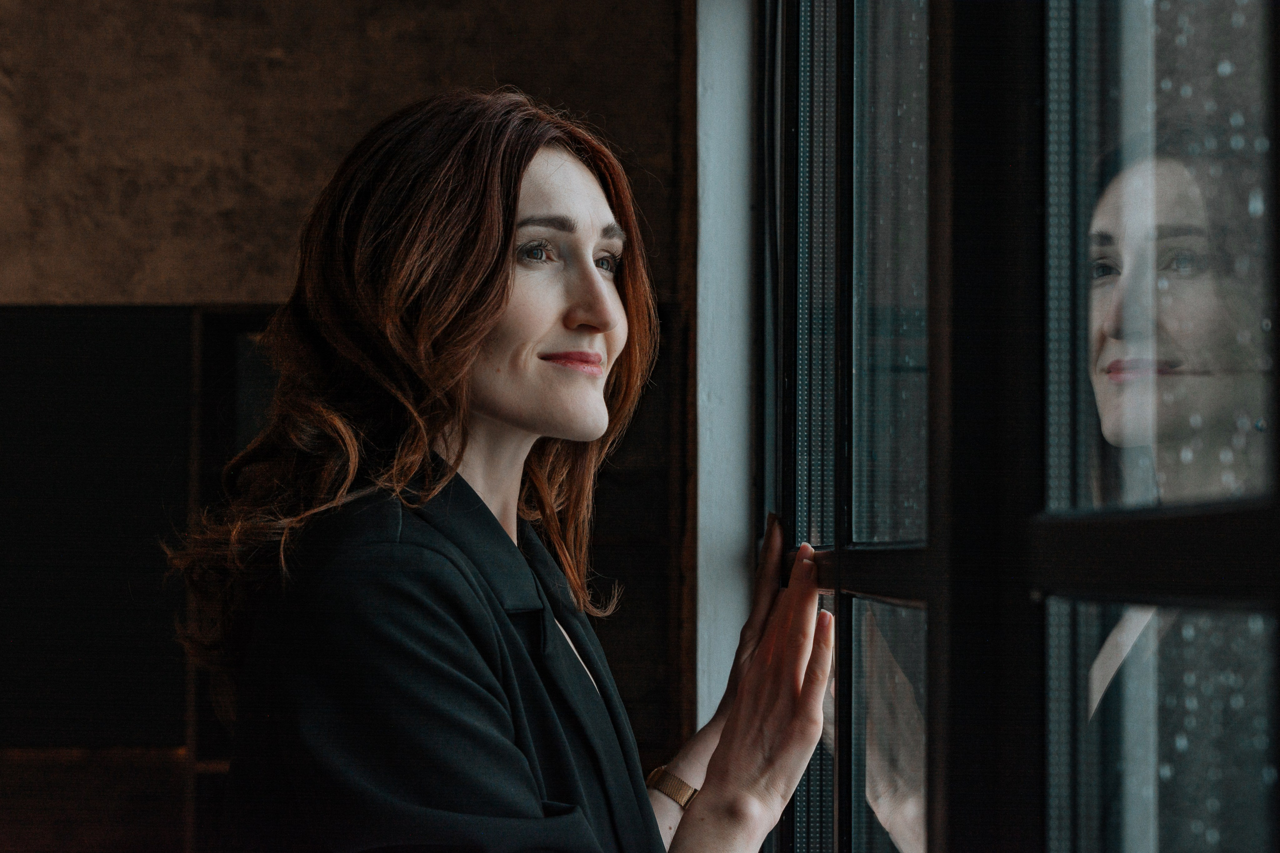 На ней надет мужской пиджак из дорогой ткани, небрежно наброшенный на обнаженное тело. Приталенный силуэт подчеркивает изящные изгибы талии и бедер. Рукава пиджака коротковаты, открывая стройные запястья.