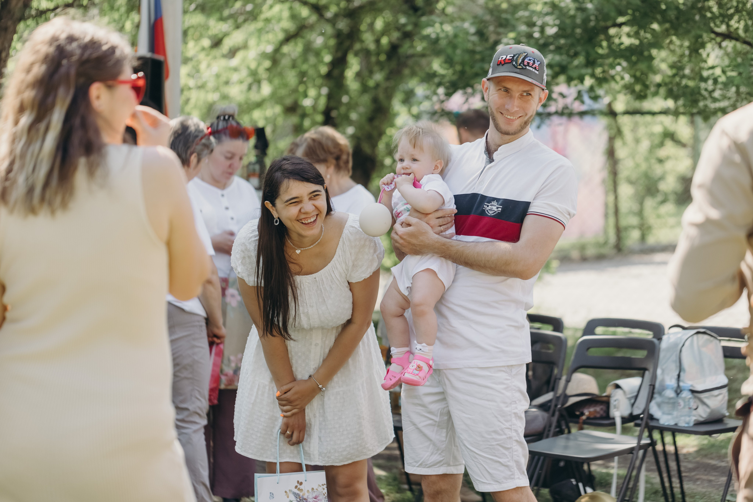 Молодая семейная пара с ребенком поздравляет будущих родителей