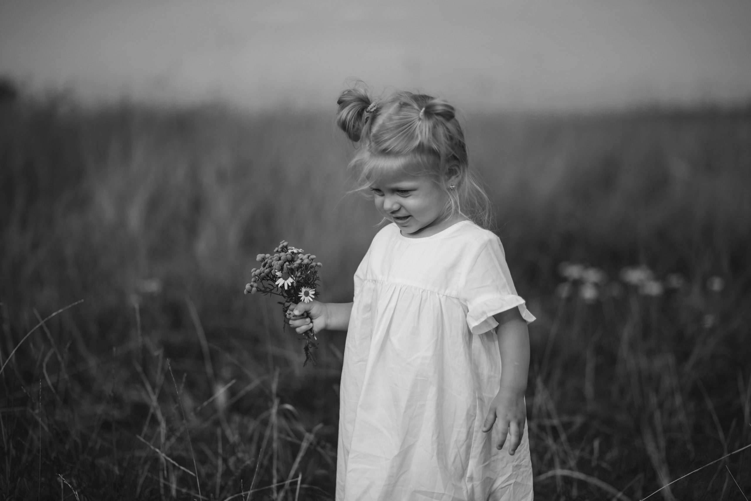 Little girl standing in tall grass and smiling