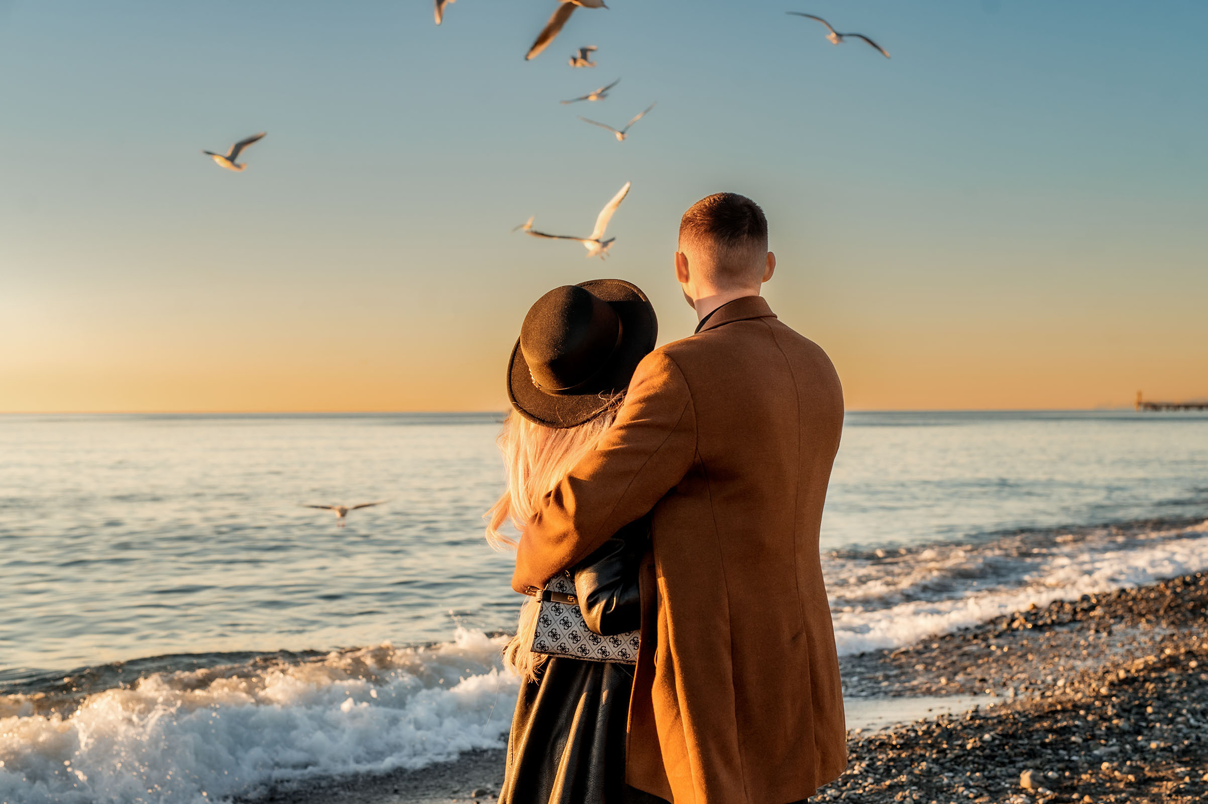 Фотосессия влюбленных у моря на закате.