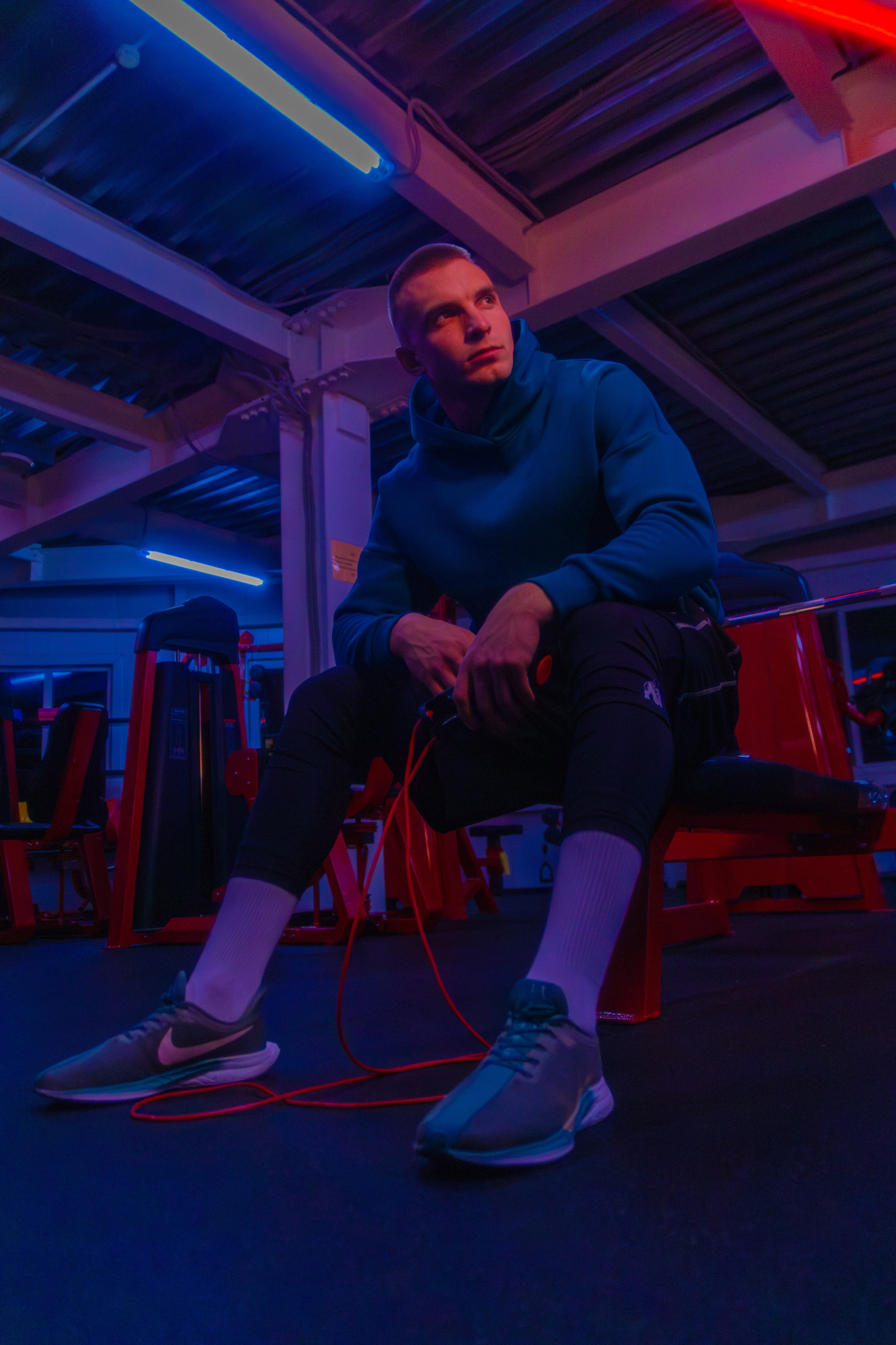 Эффектная фотография тренера в современном зале, передающая силу и харизму.