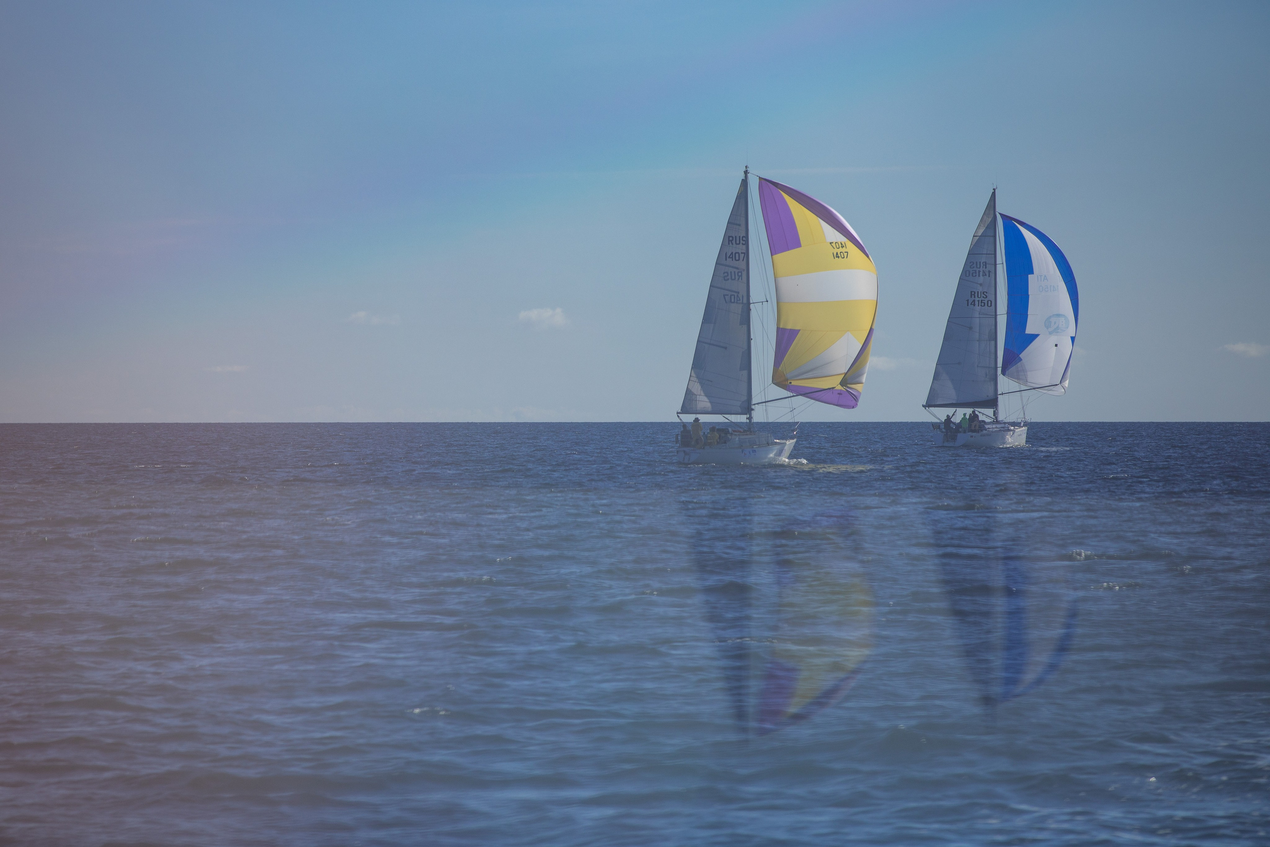 Две яхты отражаются в воде за счет оптического эффекта от призмы.