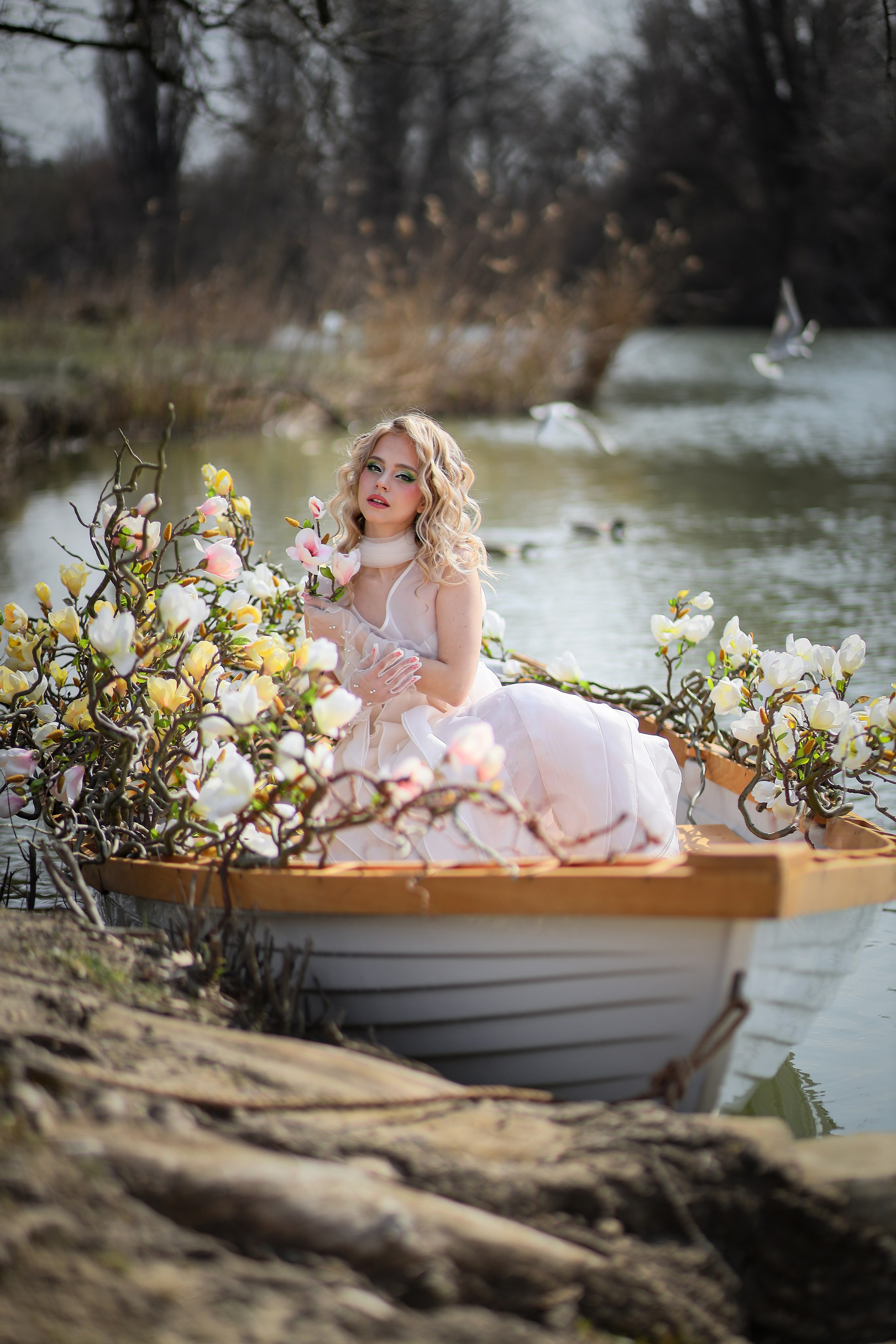 Женская индивидуальная фотосессия на лодке на озере Рица с профессиональным фотографом.