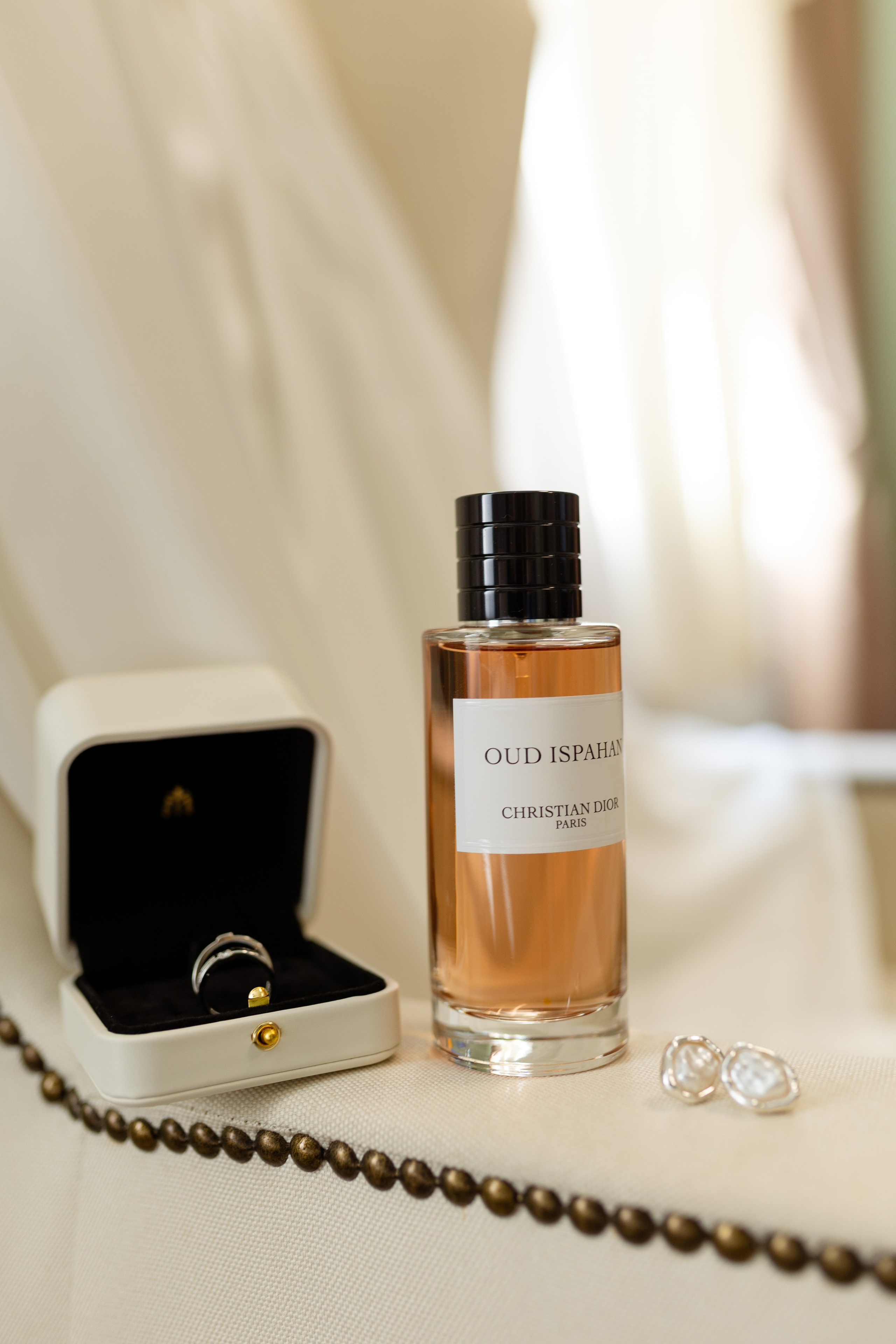 На фото кольцо,серьги, бусы и бутылочка с парфюмерией.