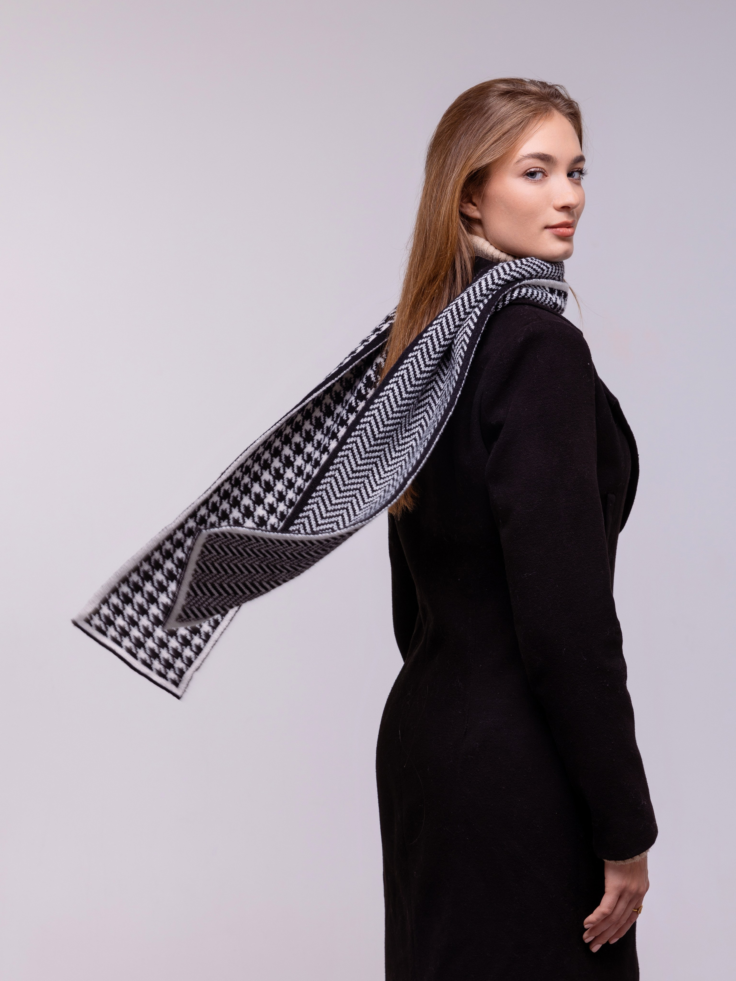 шарф с разными рисунками развивается за спиной девушки.