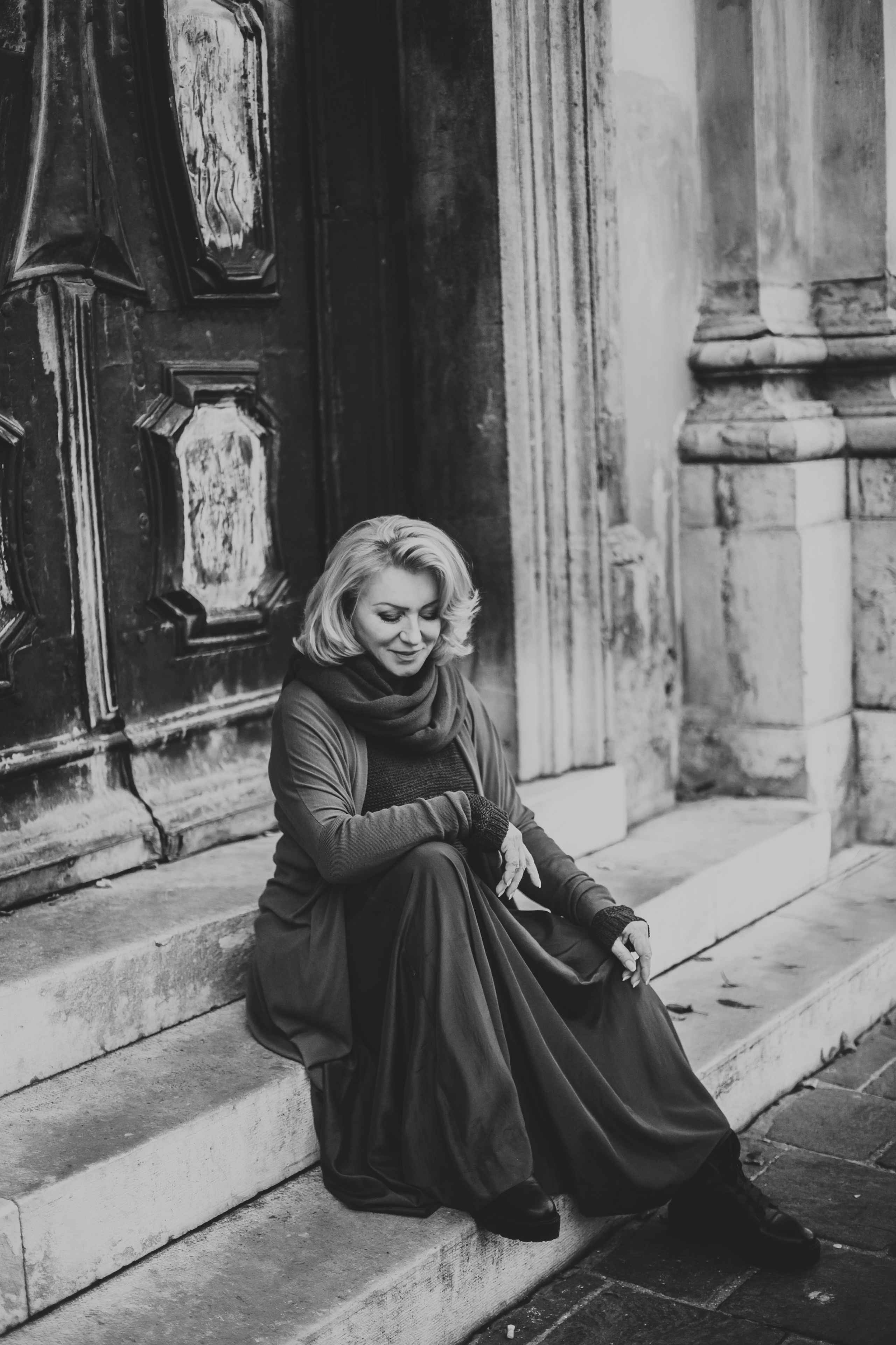 блондинка сидит на каменных ступенях