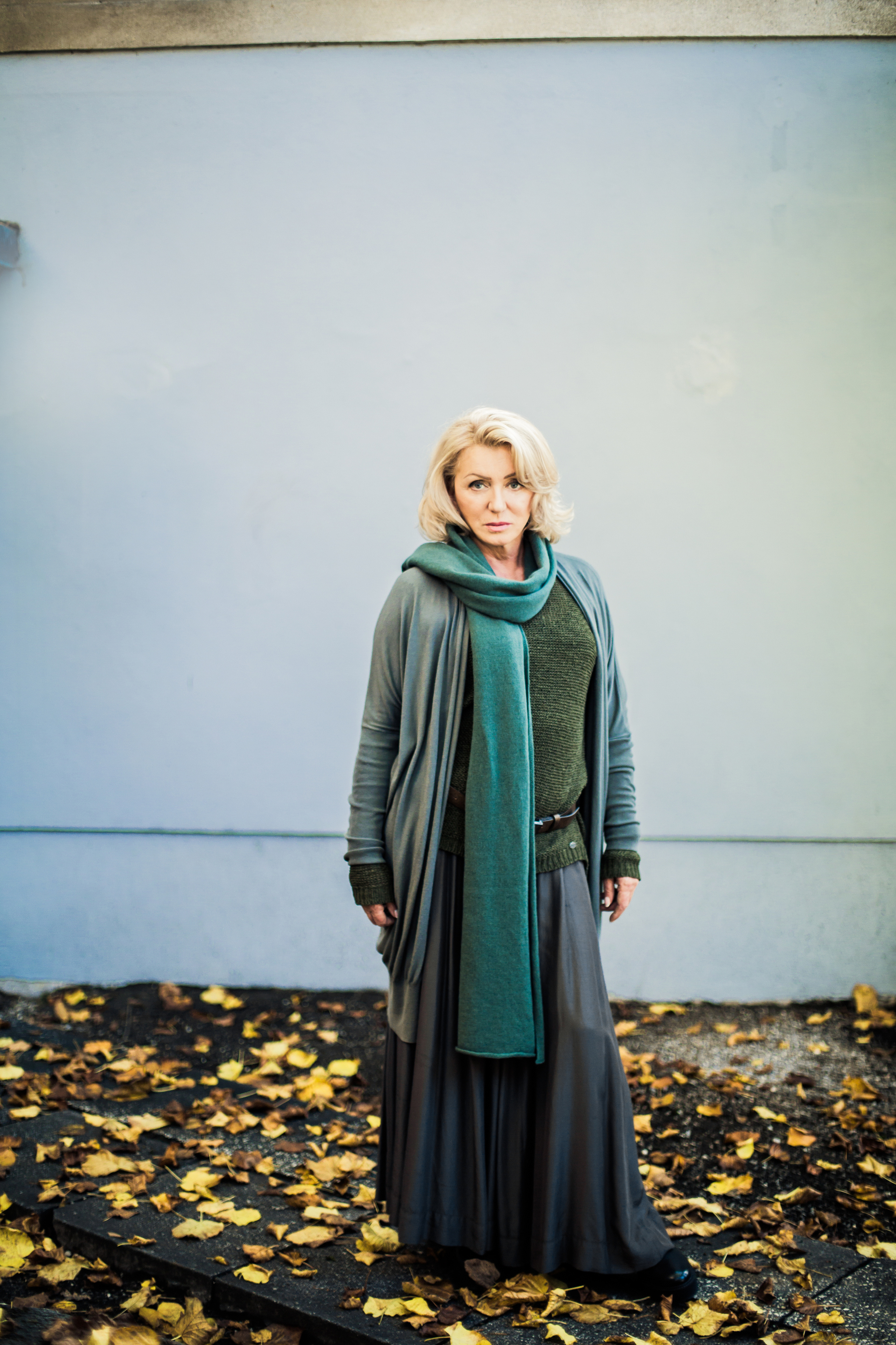 стильная взрослая женщина в серо-зеленом осенью на улице