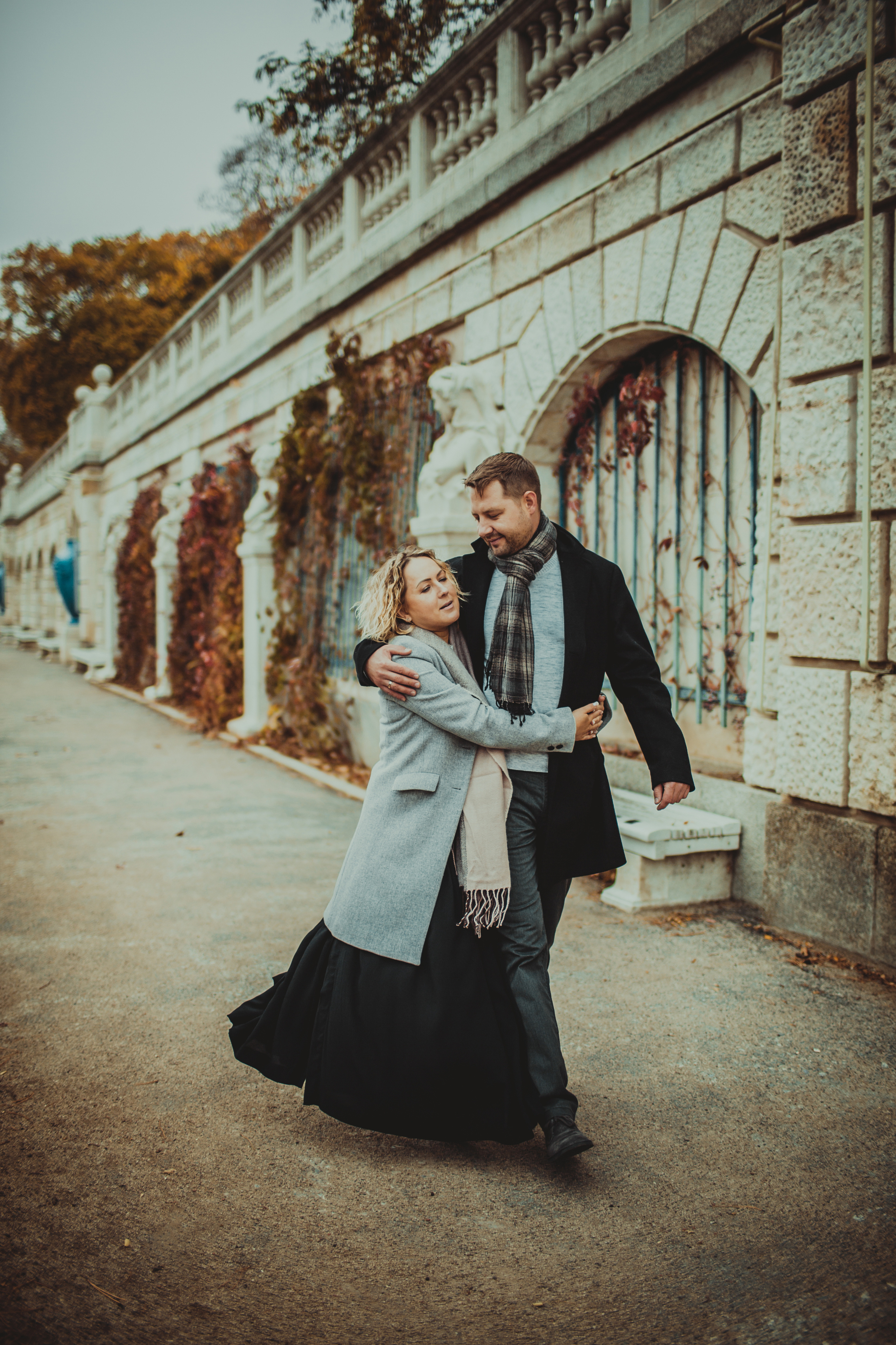 пара обнявшись гуляет по осеннему городу