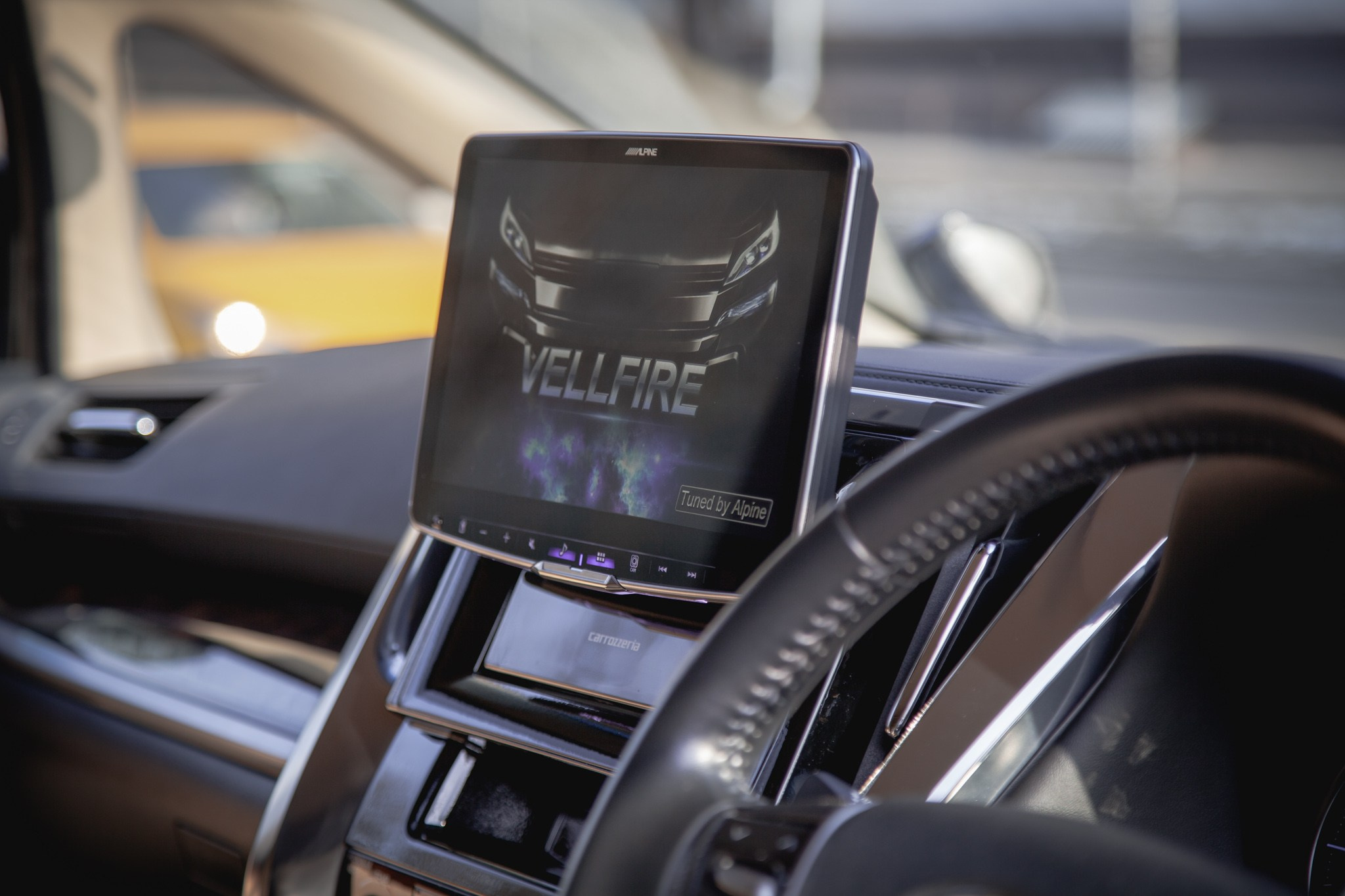 Интерьер современного авто с мультимедийной системой, рулевым колесом и автоматической коробкой передач. Черно-белый дизайн подчеркивает премиальность.