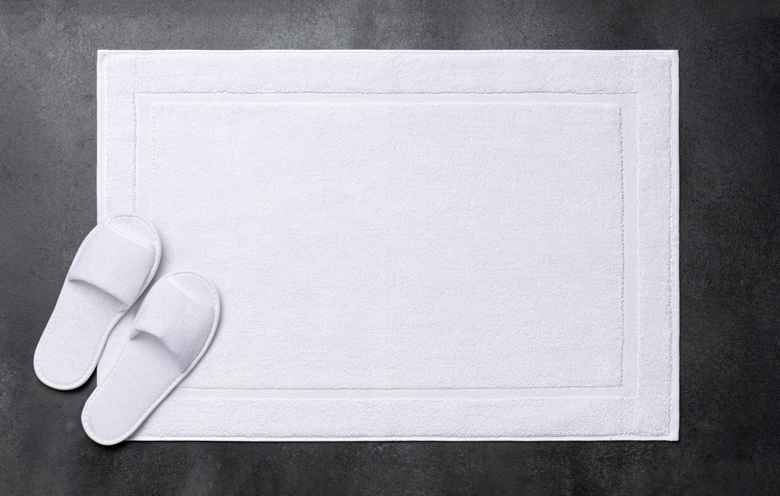 Белые тапочки на белом коврике в ванной | Интерьерная съемка для каталога