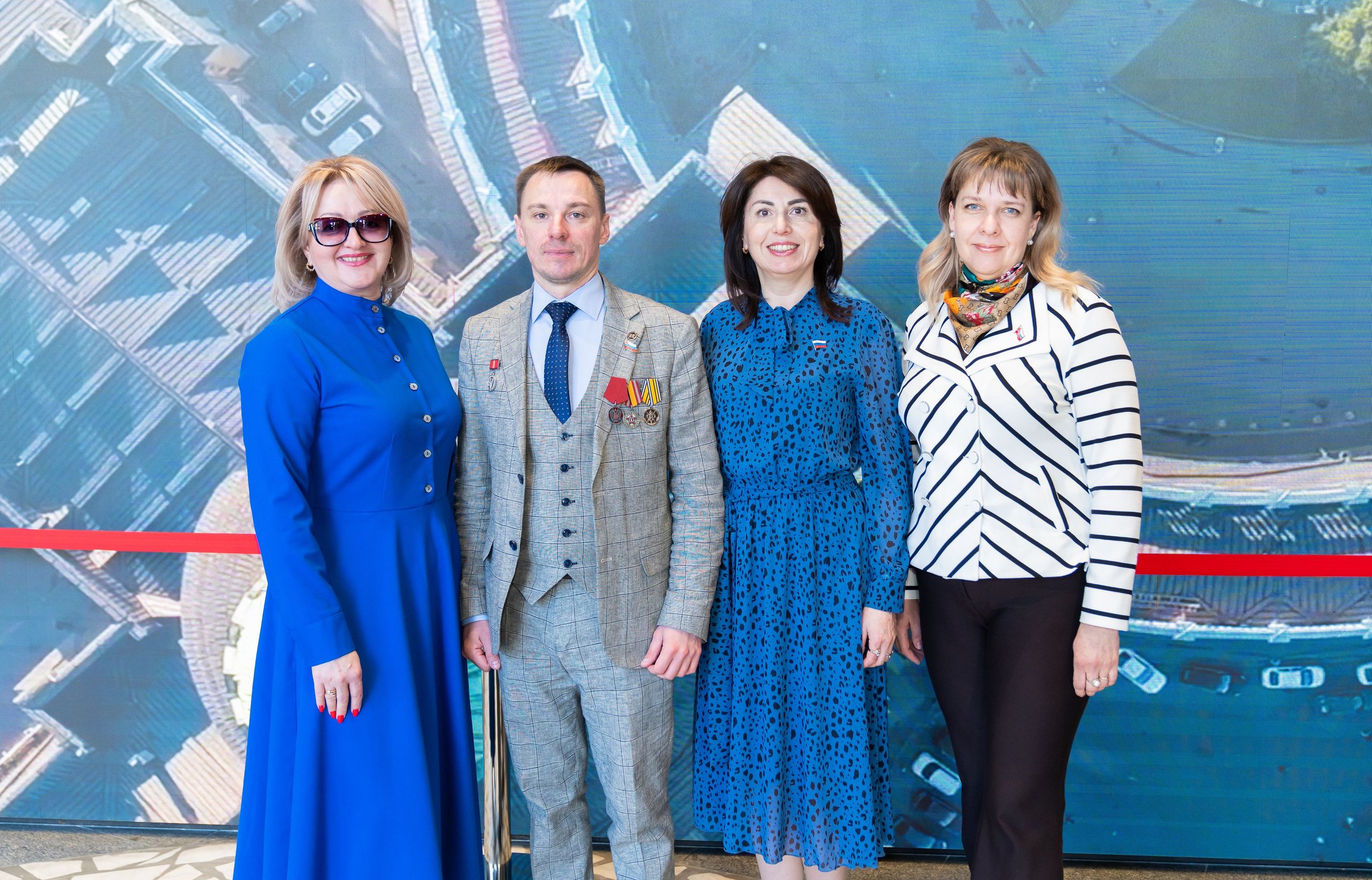 Групповое фото участников Дня местного самоуправления 2026 на фоне панорамы Санкт-Петербурга. Официальные лица и сотрудники администрации. Фотография Евгения Мальцева.