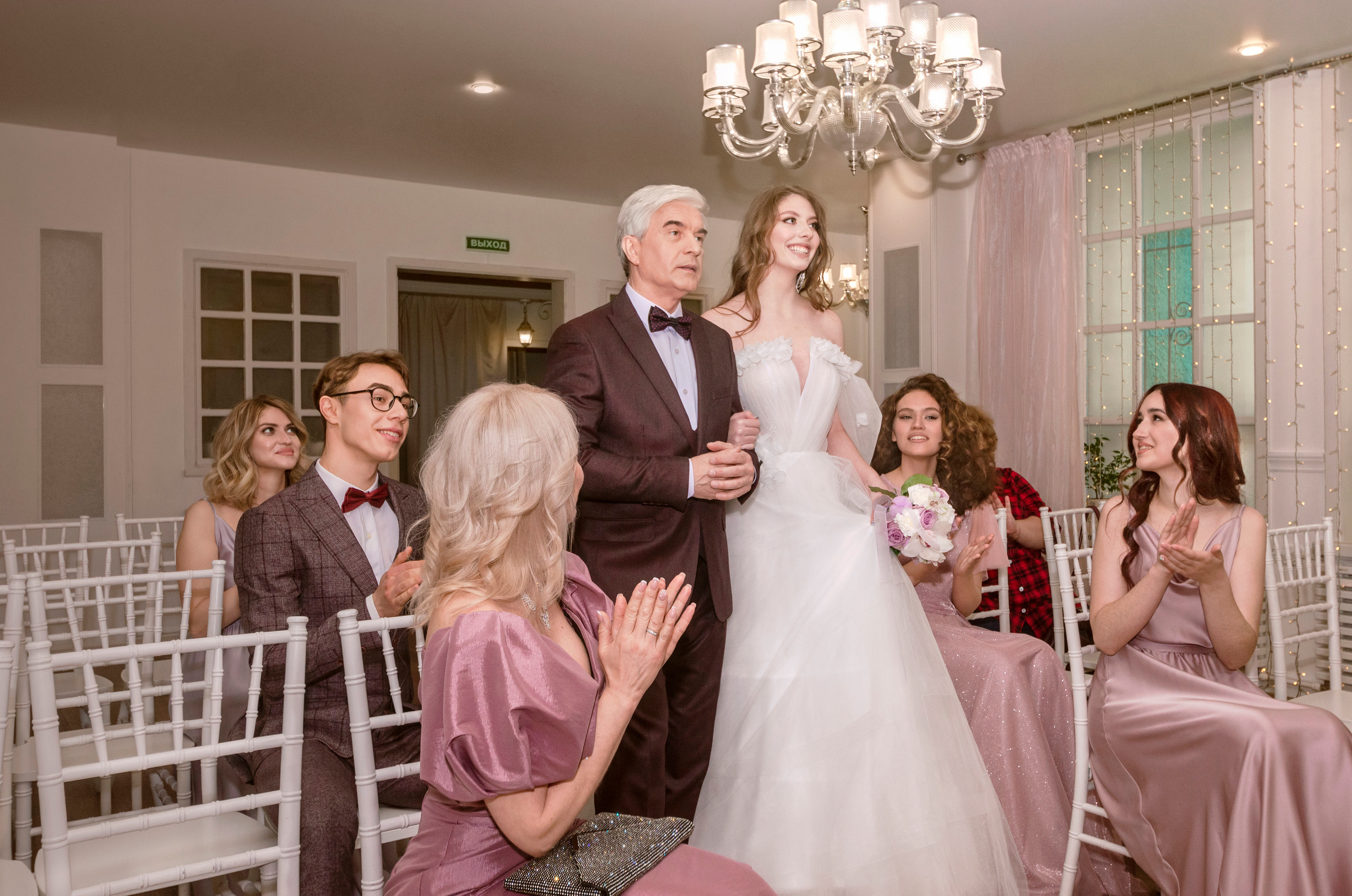 Выездная регистрация в стенах ресторана, гости встречают невесту с её отцом.