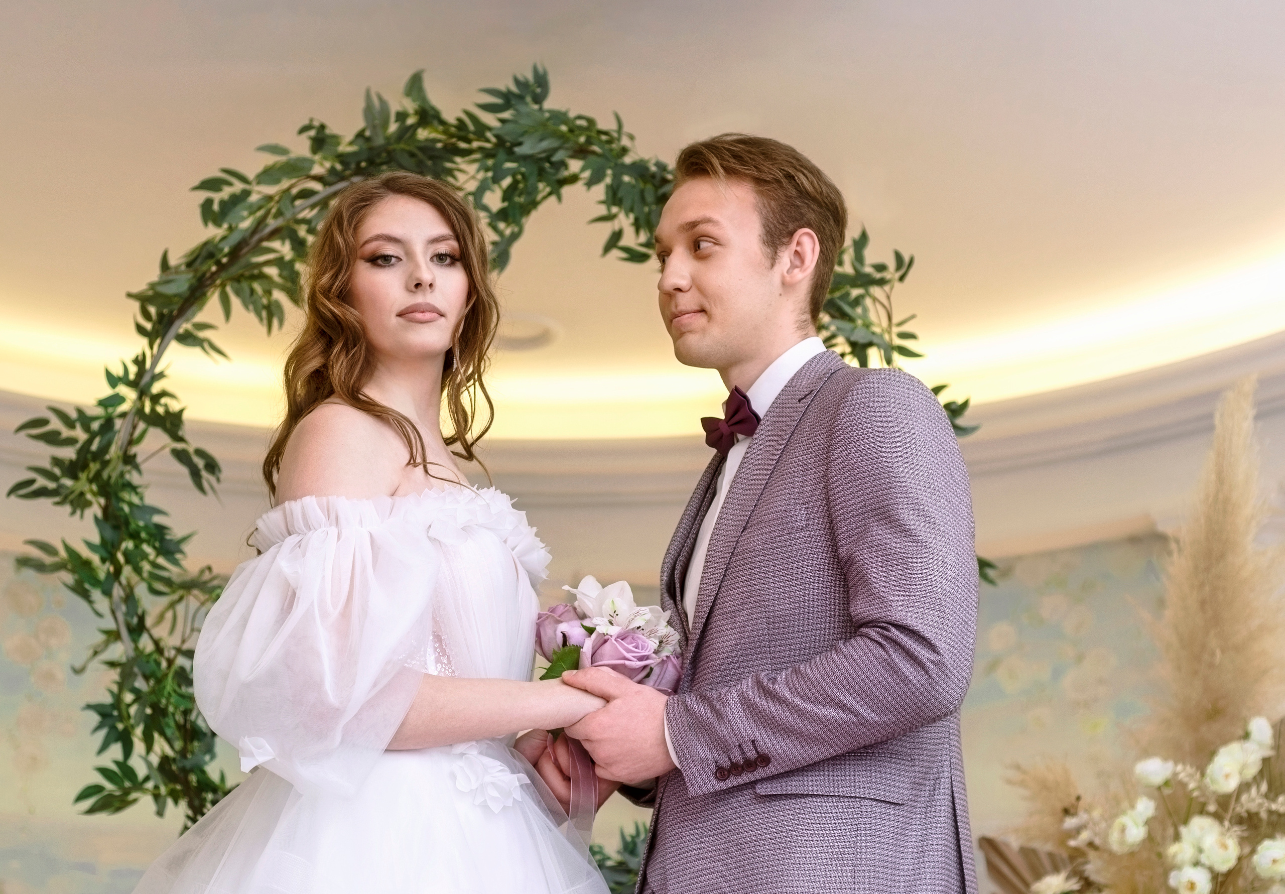 Жених влюбленно смотрит на строгую невесту.