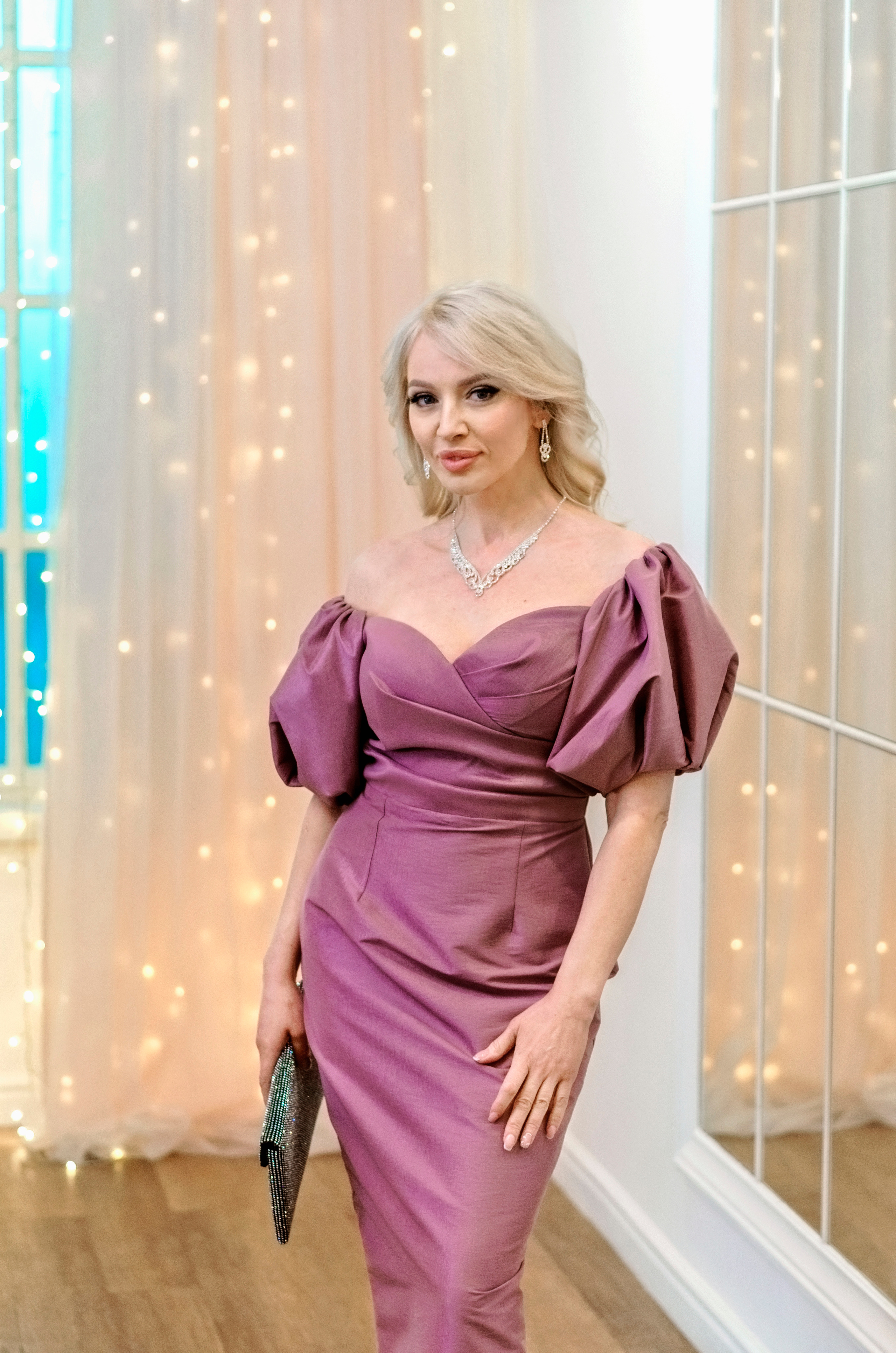 Портрет элегантной обаятельной женщины в роскошном розовом платье.