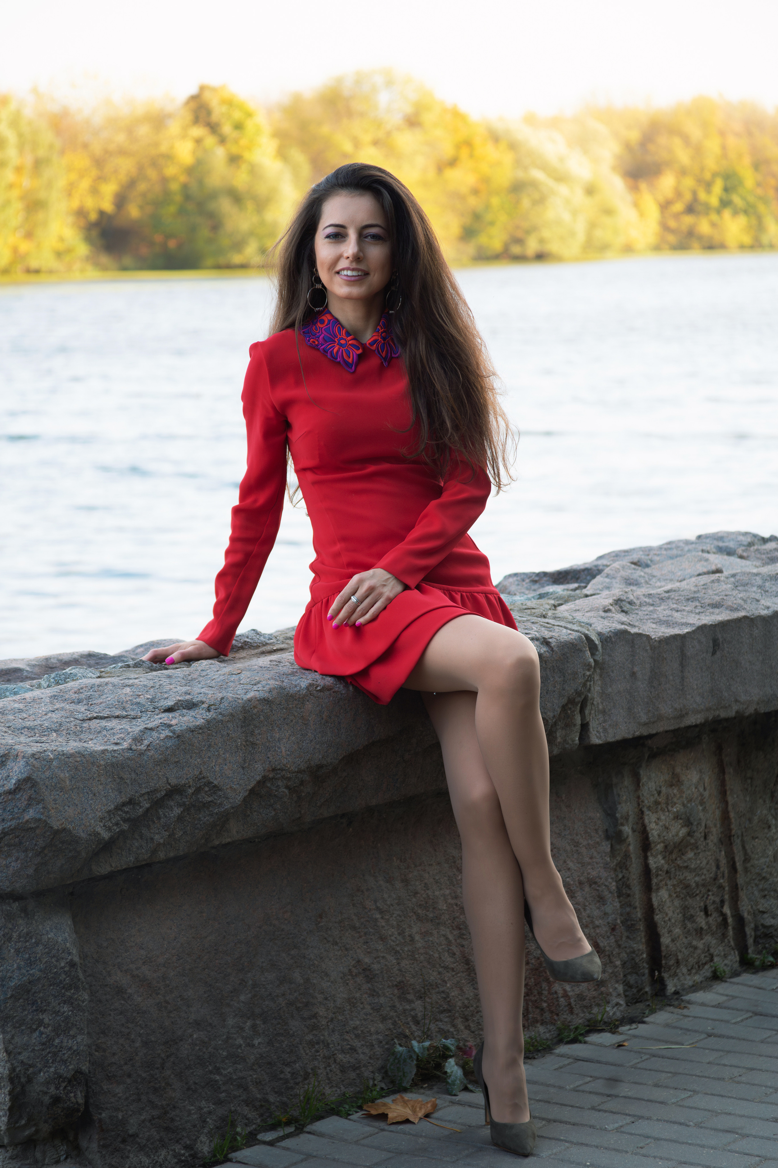 Девушка в красном платье на набережной осенью