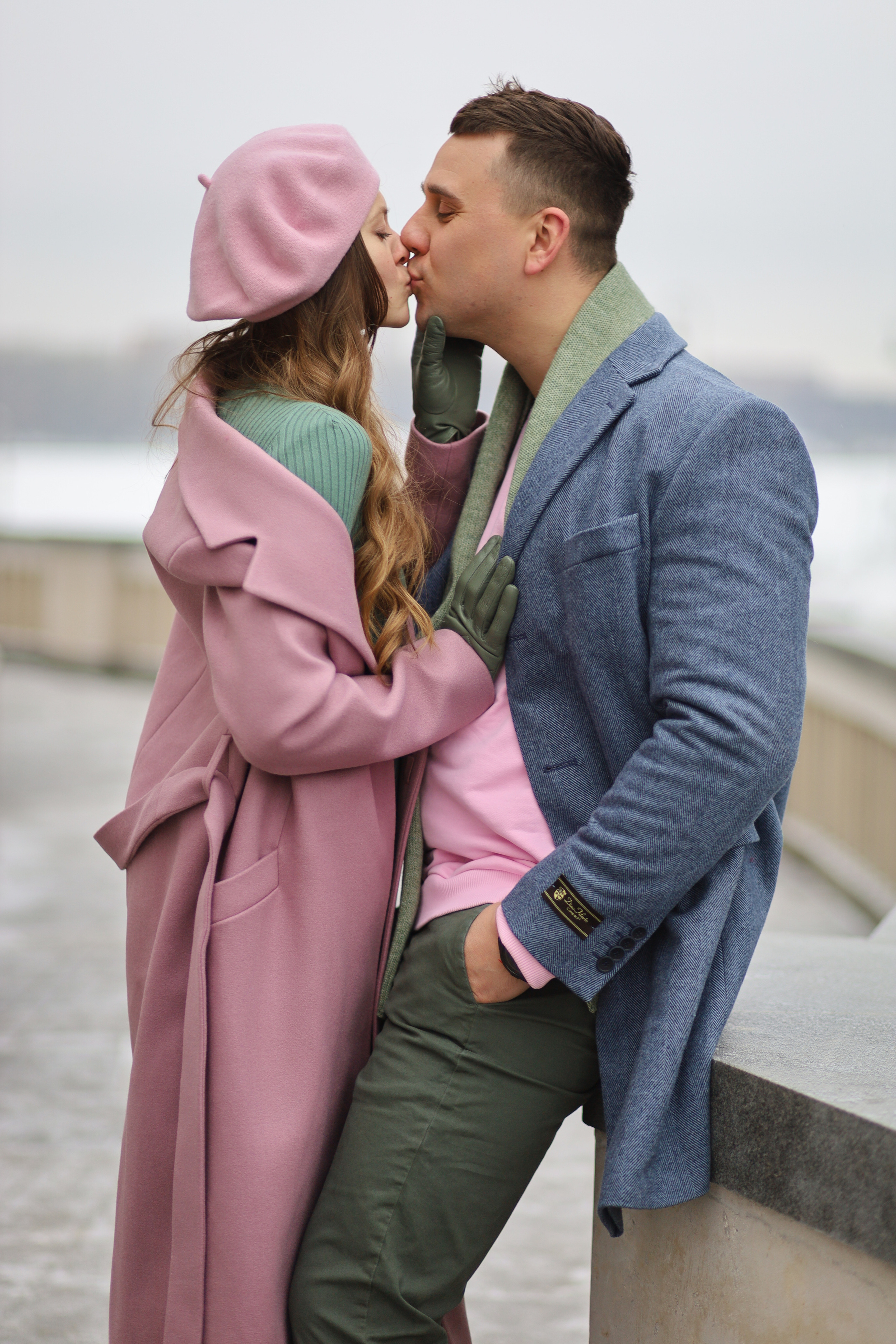 Девушка целует парня на фотосессии