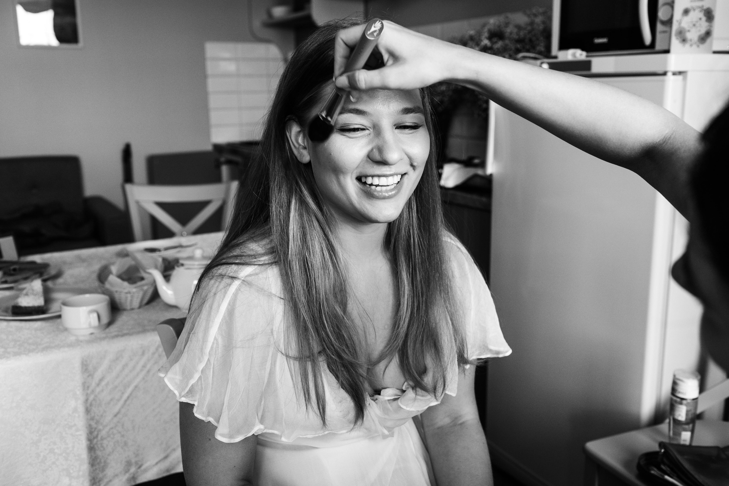 невесте делает макияж  визажист в номере  отеля перед регистрацией