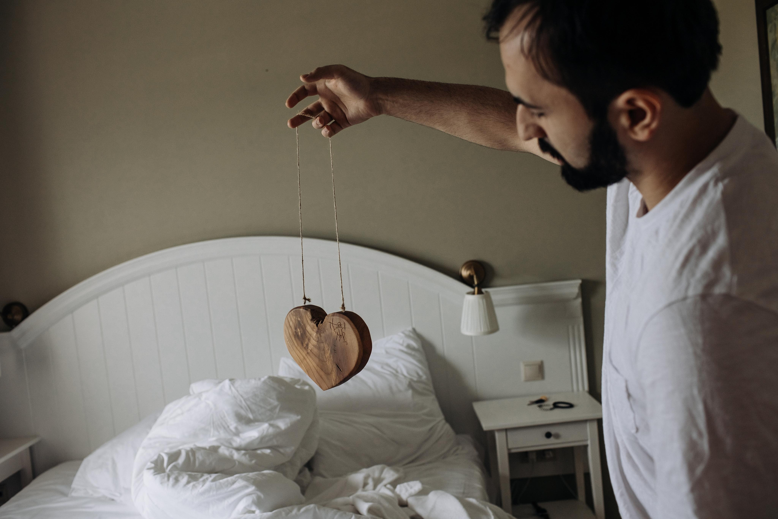 жених позирует со свадебным подарком в номере отеля на свадьбе