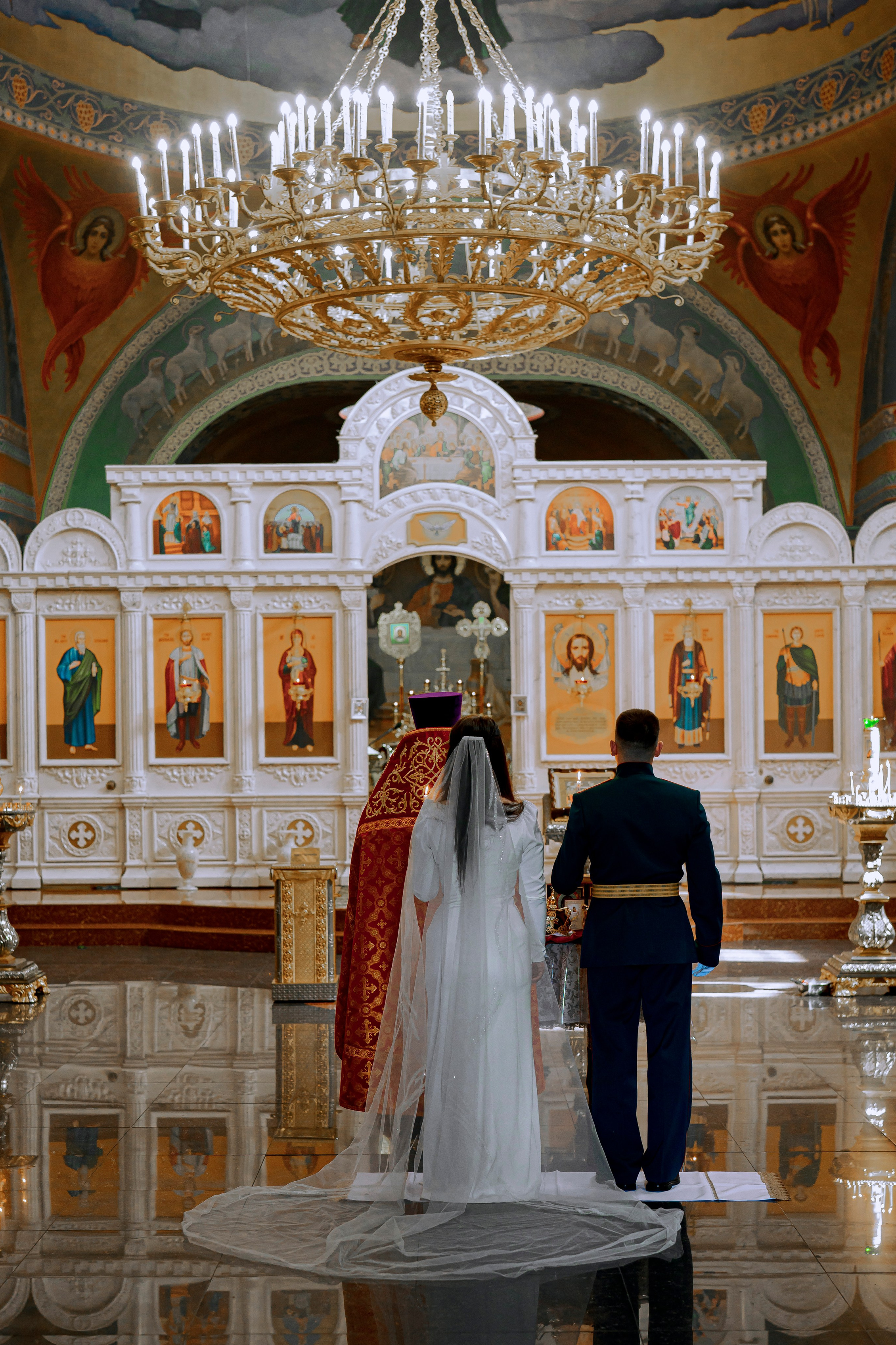 Жених и невеста в голубых одеждах в храме на церемонии обряда  венчание