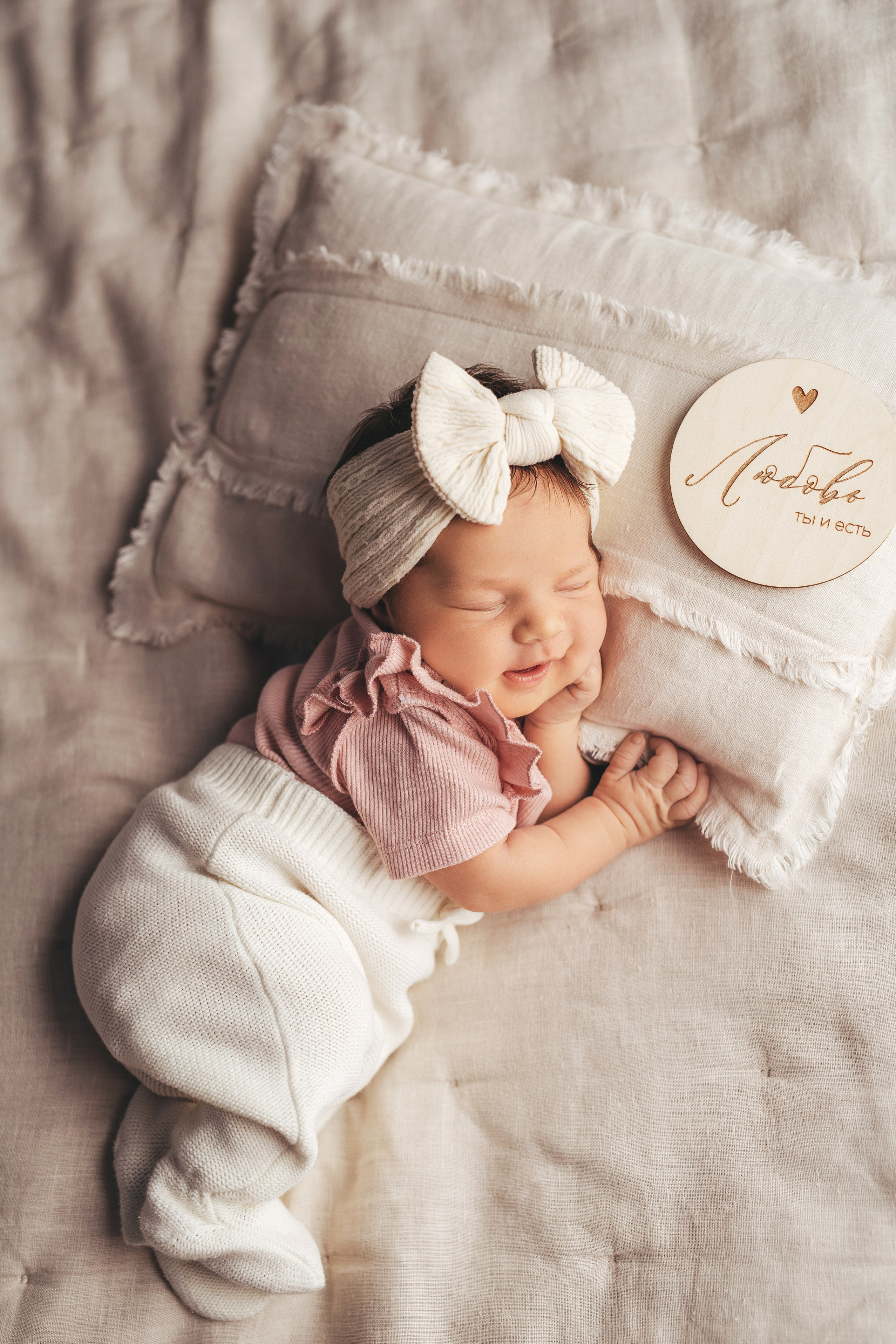 Новорожденный малыш с голыми ножками  крепко спит обняв маленького медвежонка, пока его фотографирует фотограф новорожденных из Иванова