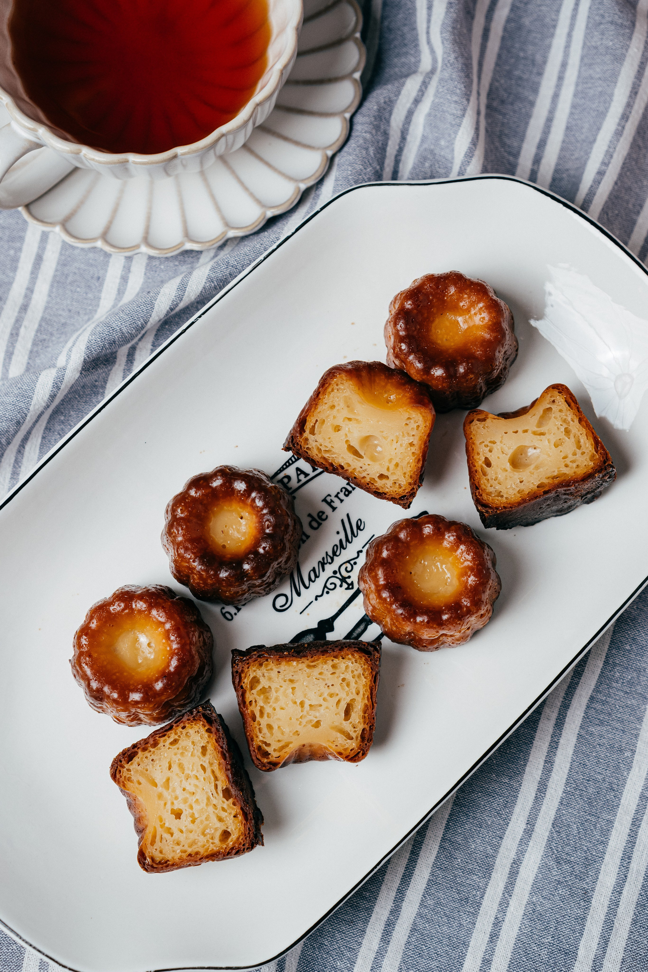 Food photo десерт канеле в разрезе с чашкой чая французское кафе фудфото