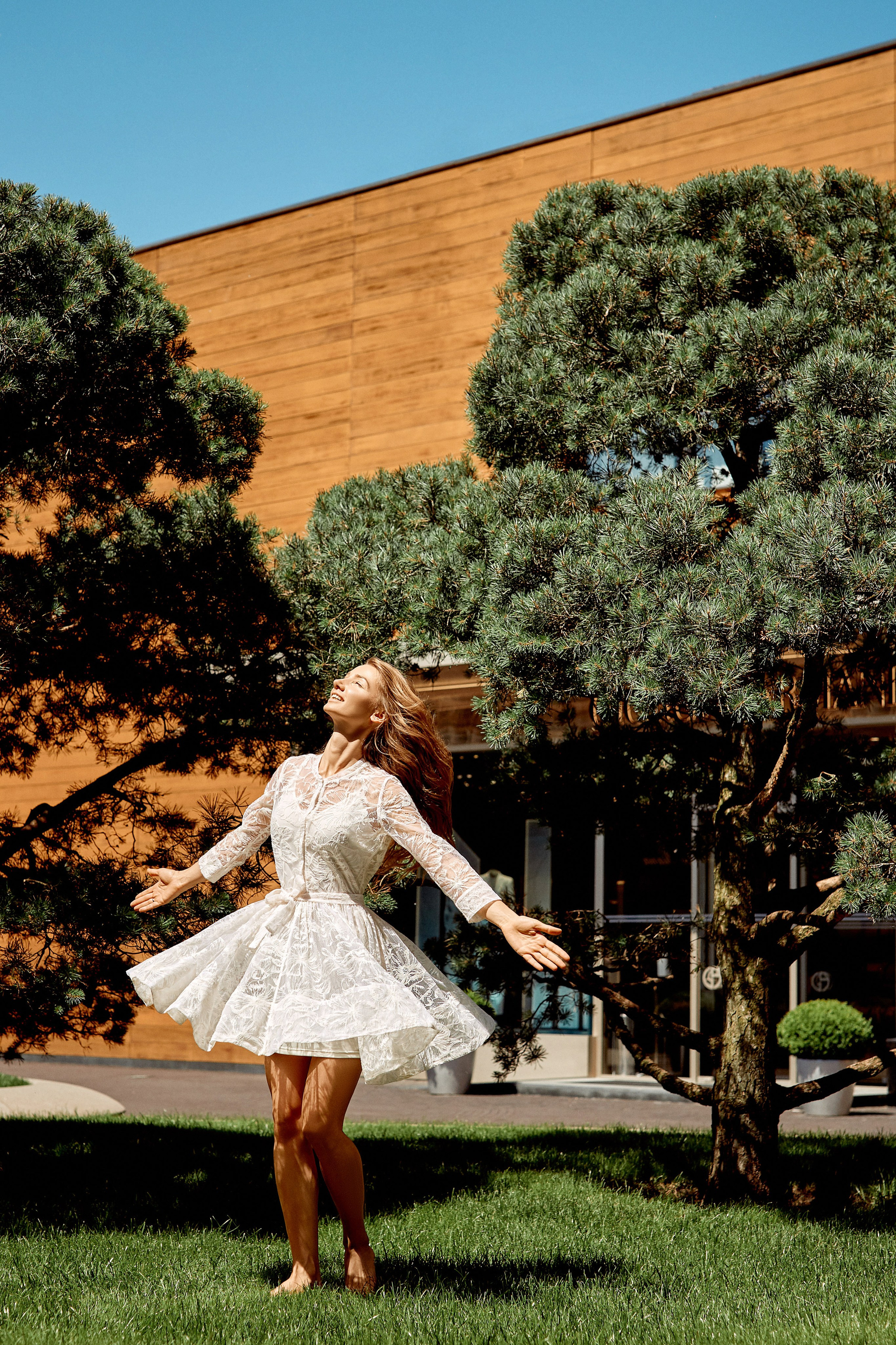 Фотограф свадебных мероприятий снимает для молодоженов в Барвиха Luxury Village – кадры со свадьбы молодоженов, где невеста кружится на газоне