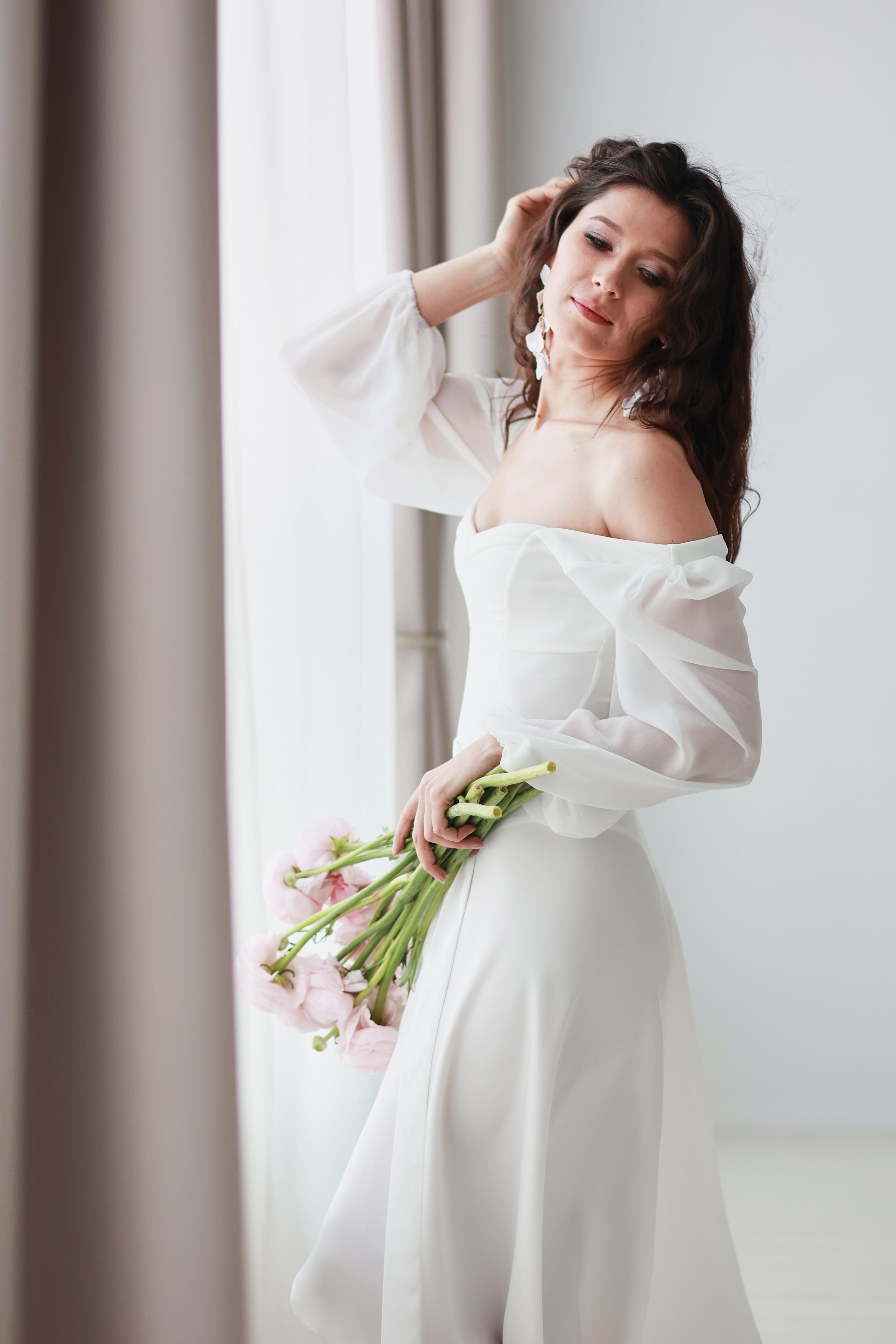 Красивая девушка позирует фотографу Ирине через широкое окно