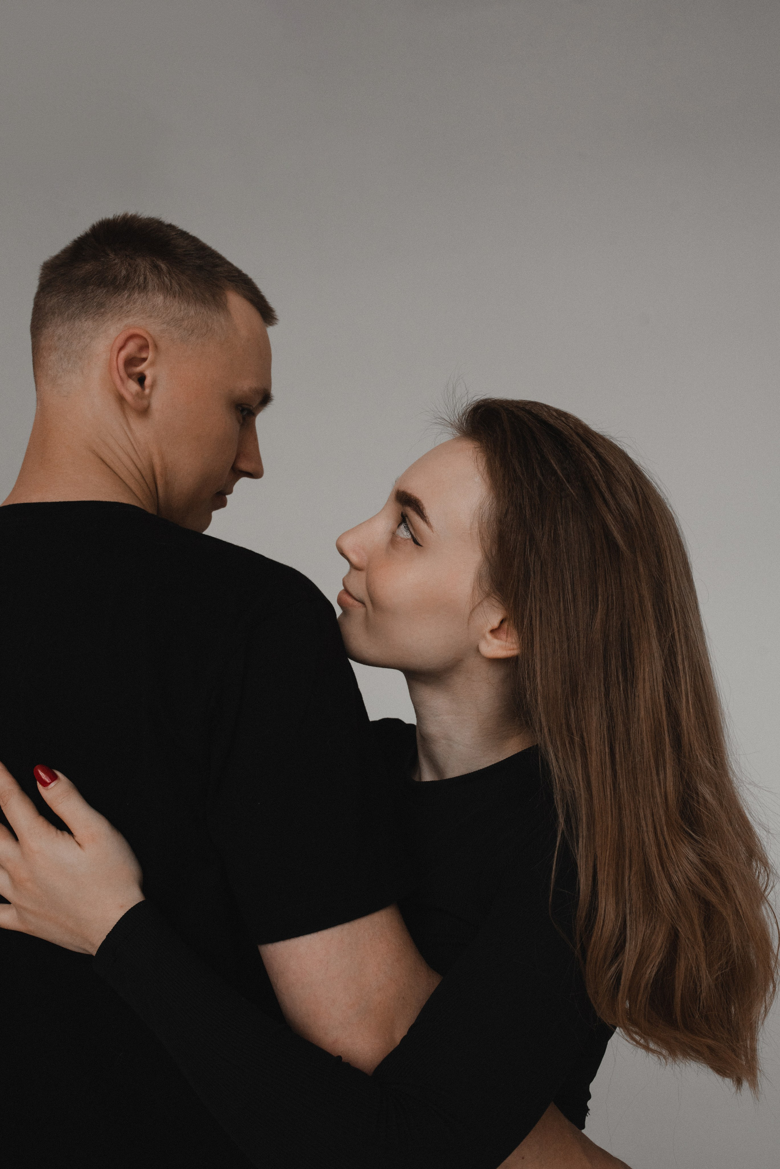 Парень в джинсовке держит девушку за подбородок