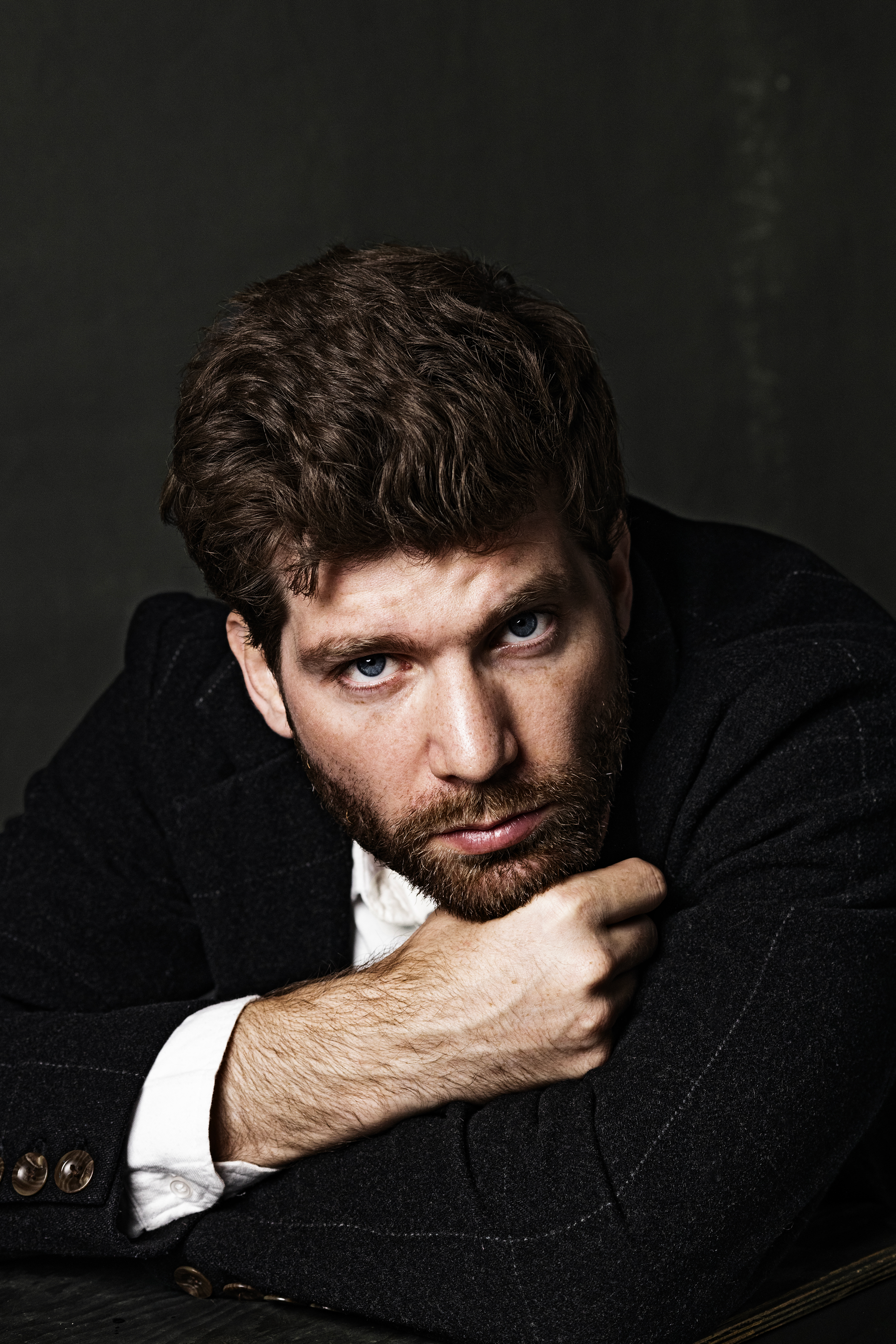 Мужской студийный портрет, классический стиль, авторская схема студийного света, профессиональная фотосъемка студийного мужского портрета, мужской портрет с драматичным освещением, крупный план мужского студийного портрета.