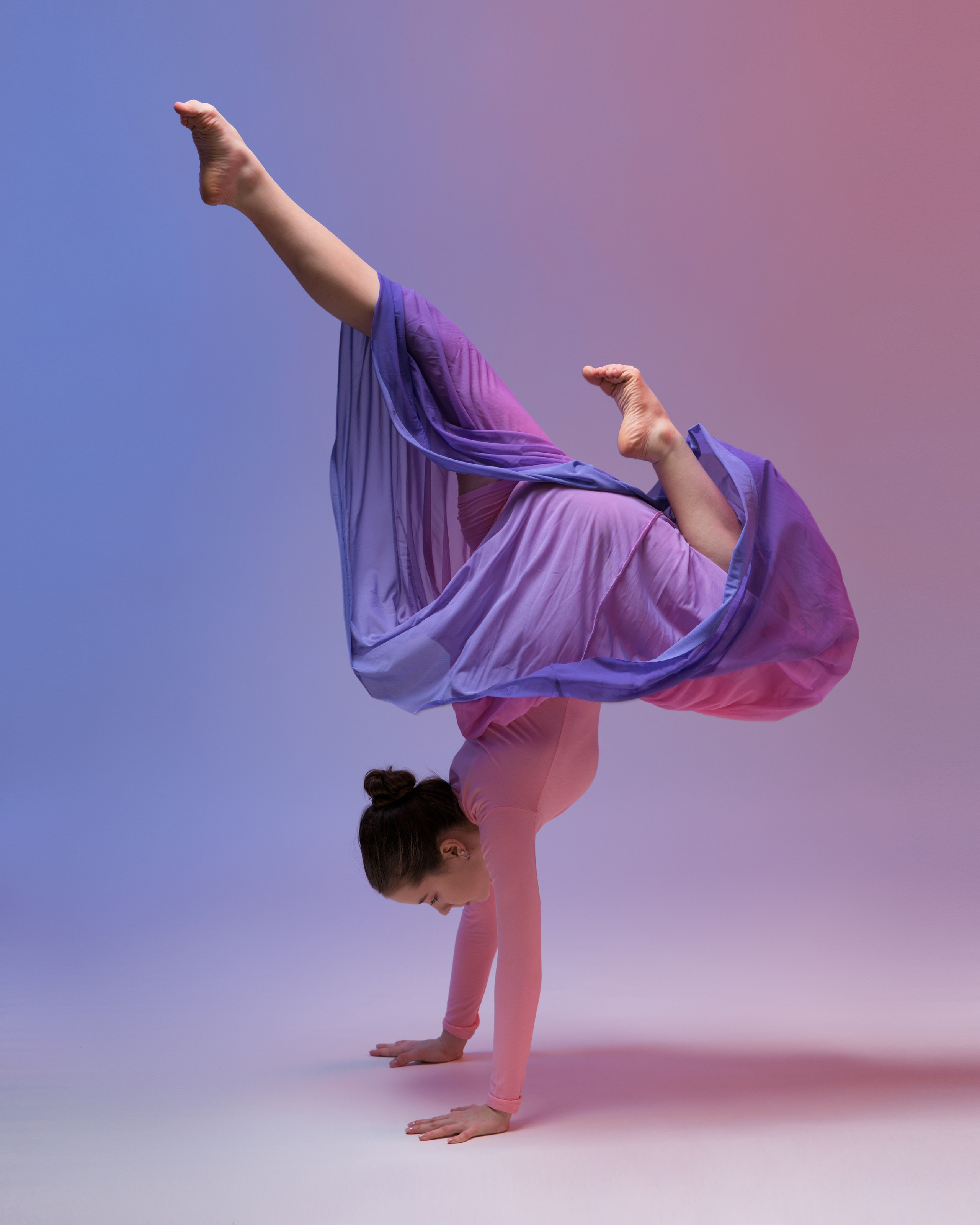 Эстетичный портрет танцовщицы в сиренево-розовой юбке, волшебная балетная съемка с мягким светом и динамикой ткани.