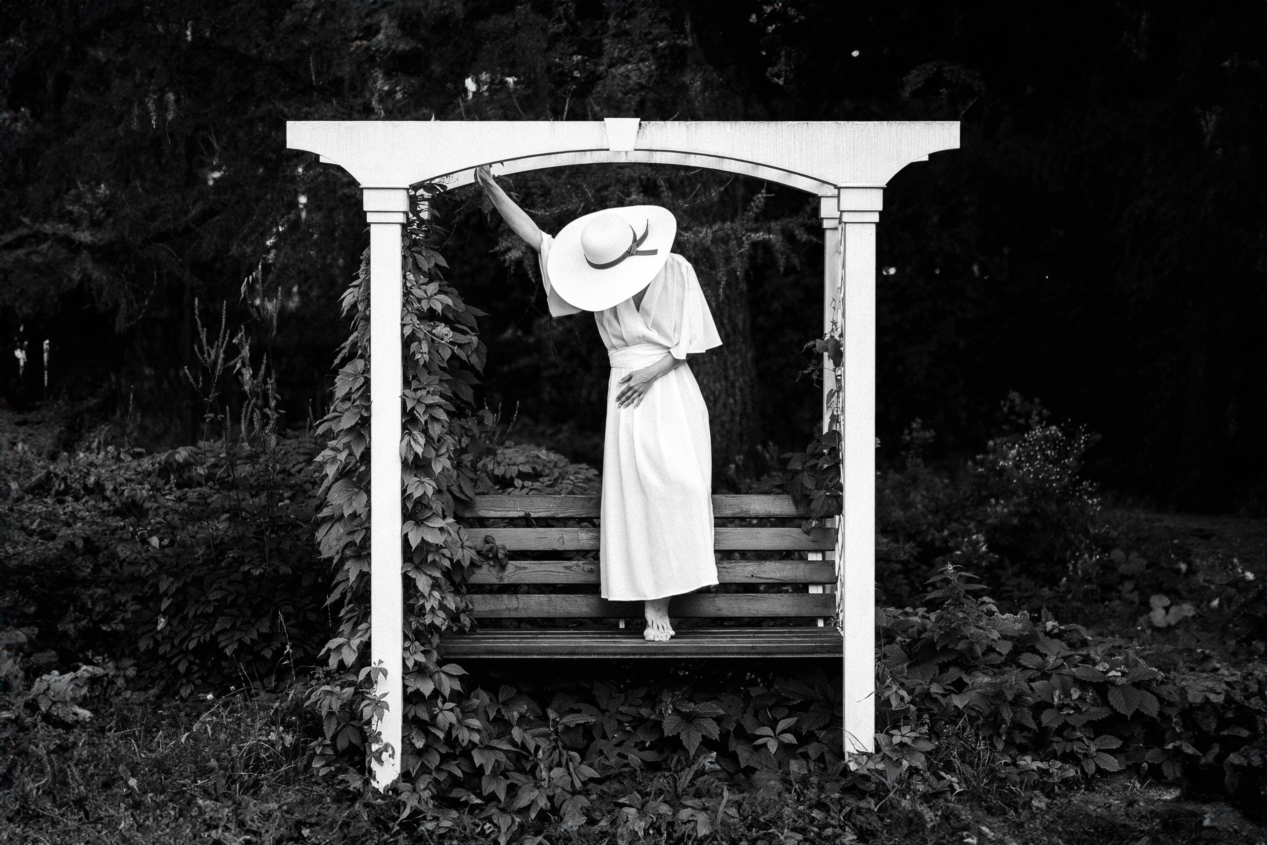 Девушка в белом платье склонила голову.