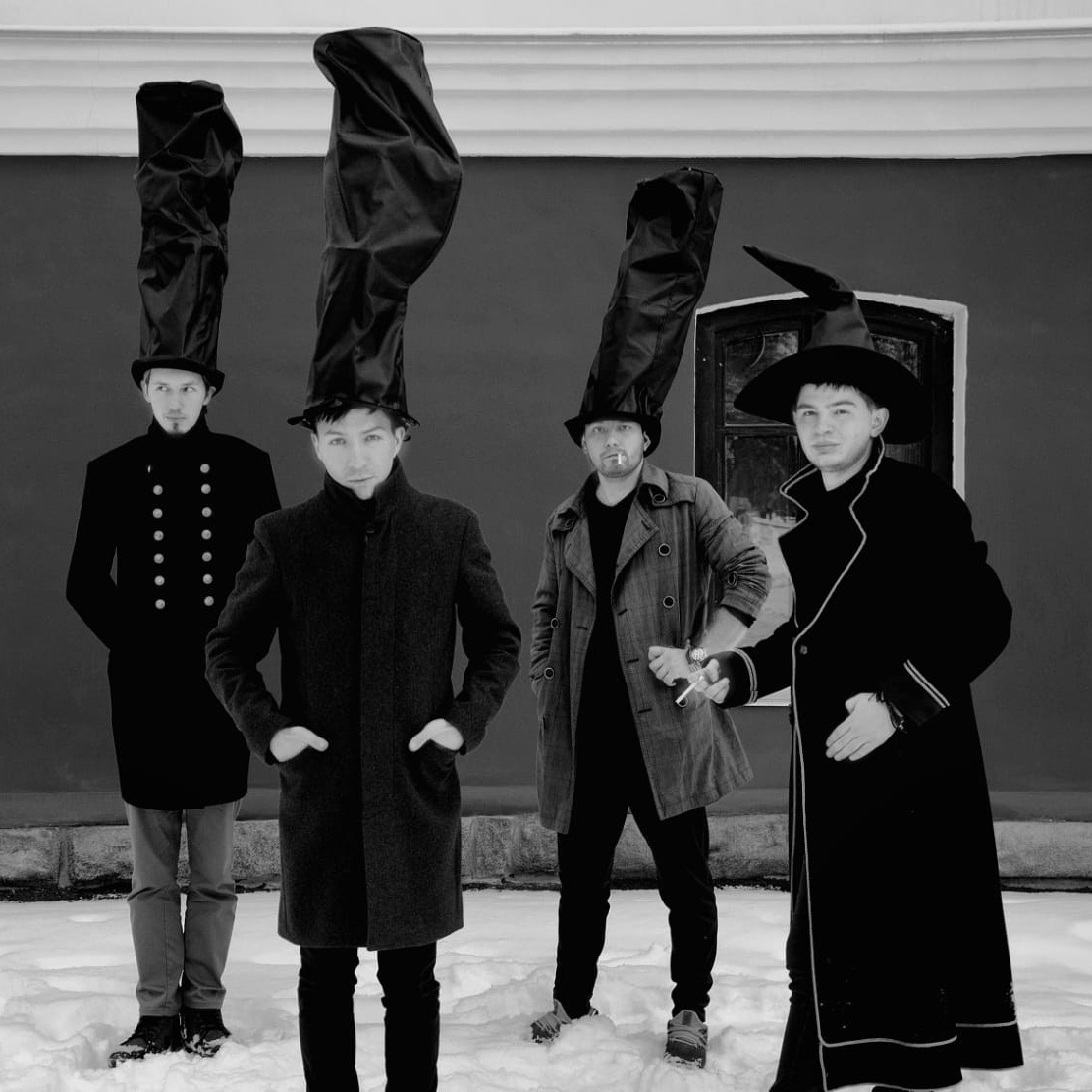  Мужчины в высоких шляпах, на фоне здания. 