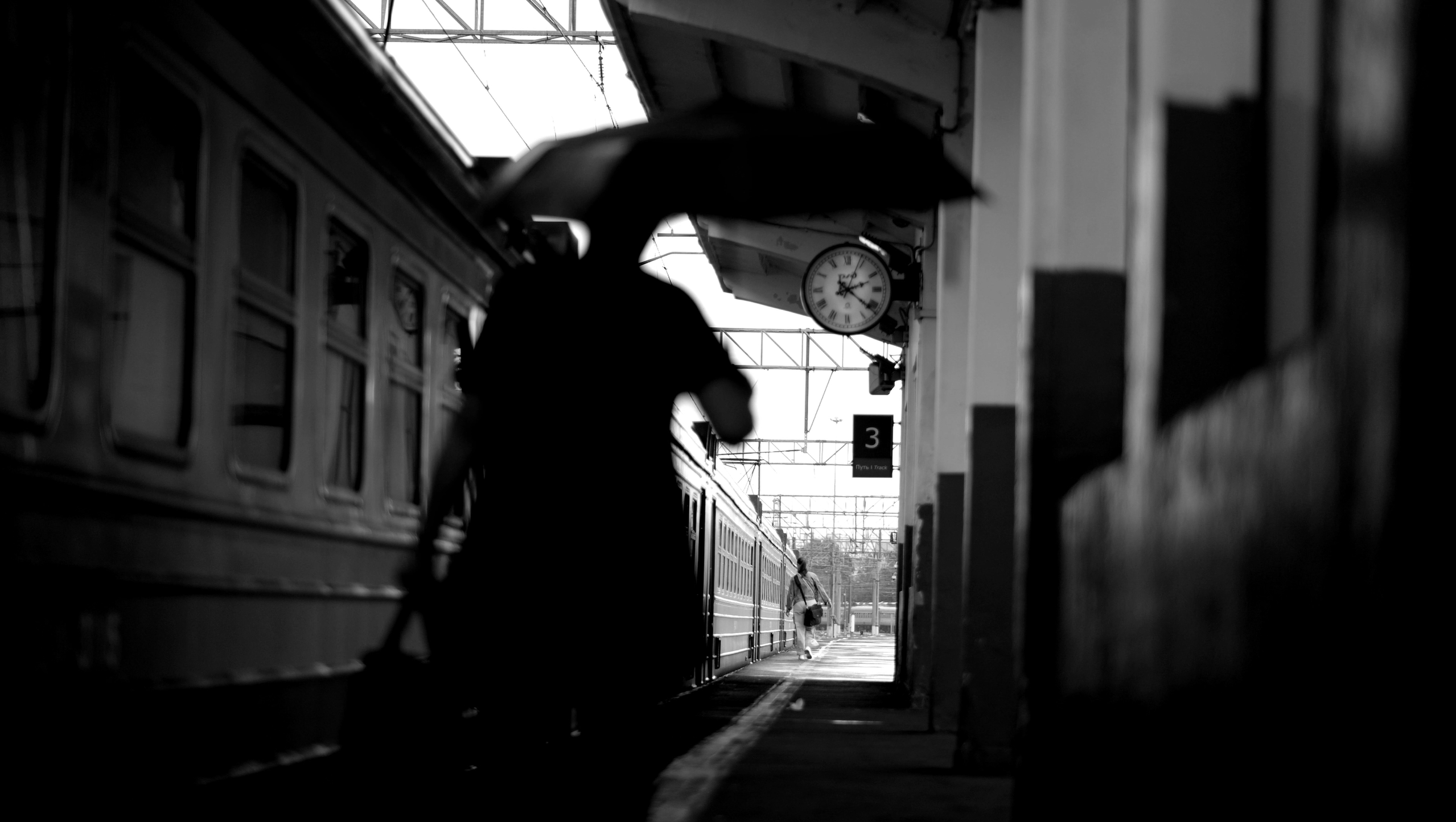 Женщина идет по перрону на поезд под дождем 