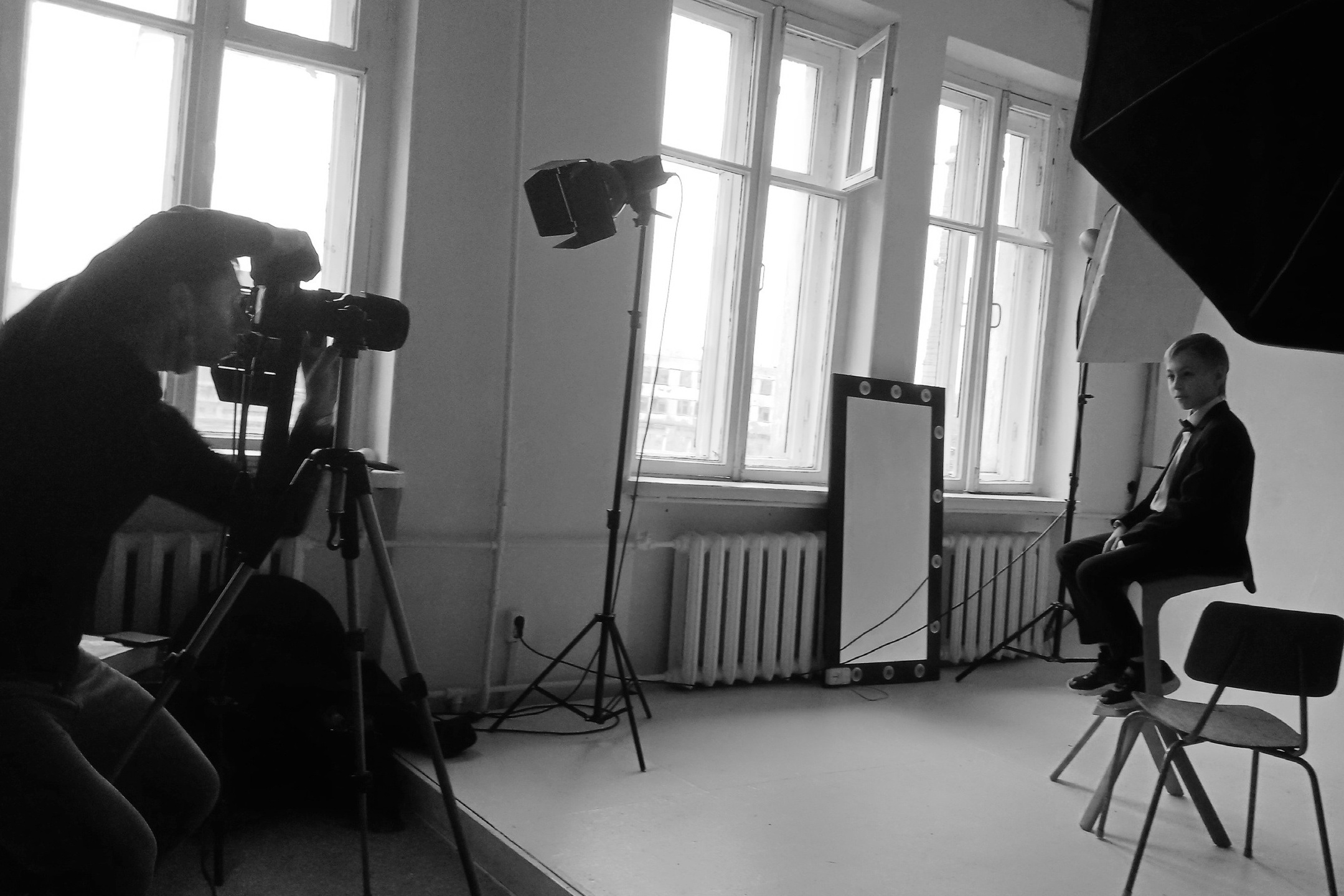 Фотограф в фотостудии показывает модели позирование.