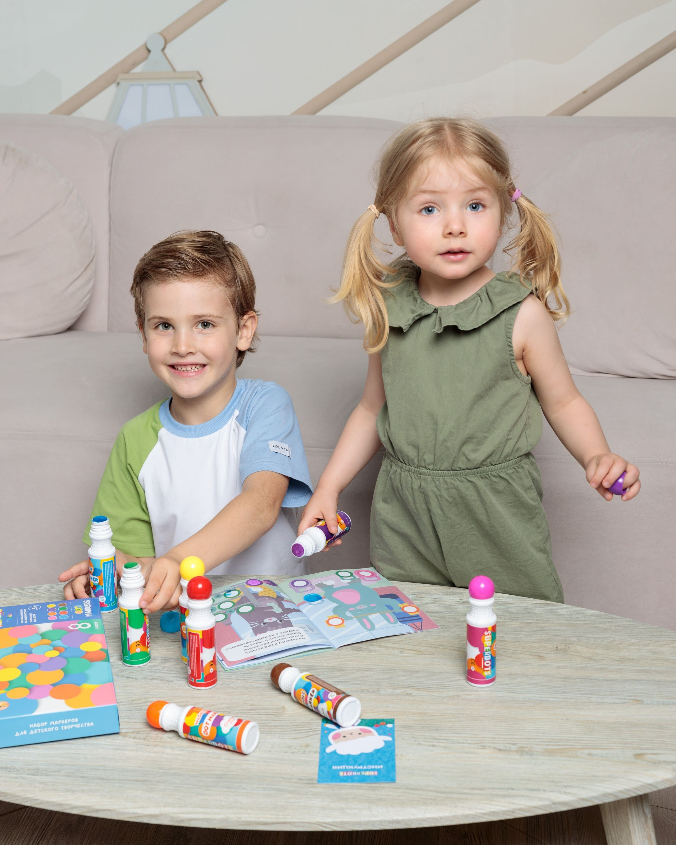 Предметная съемка детских товаров на фоне с рисунками, создавая атмосферу детского творчества.