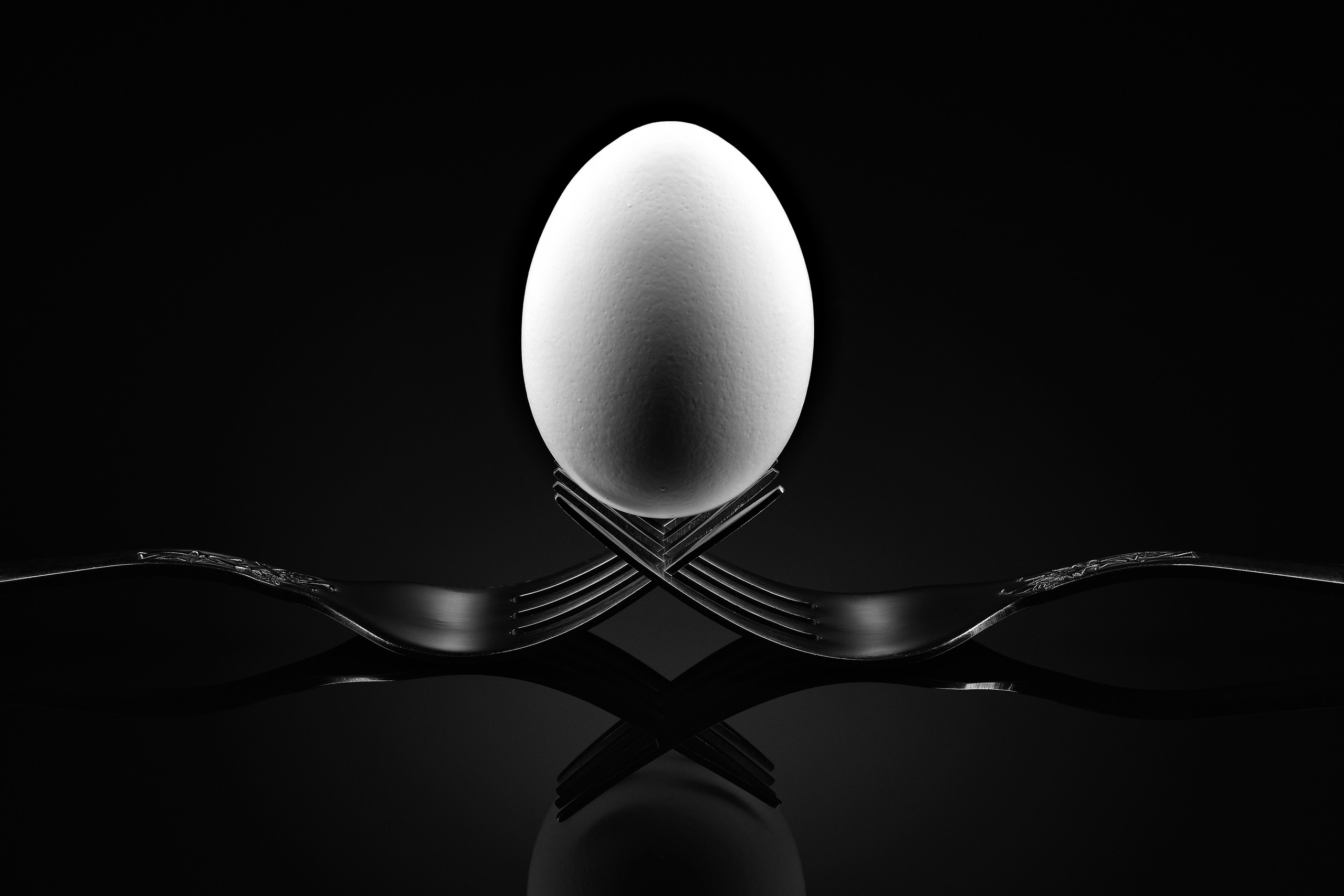 Яйцо в минималистичной композиции на тёмном фоне, концептуальная предметная фотография