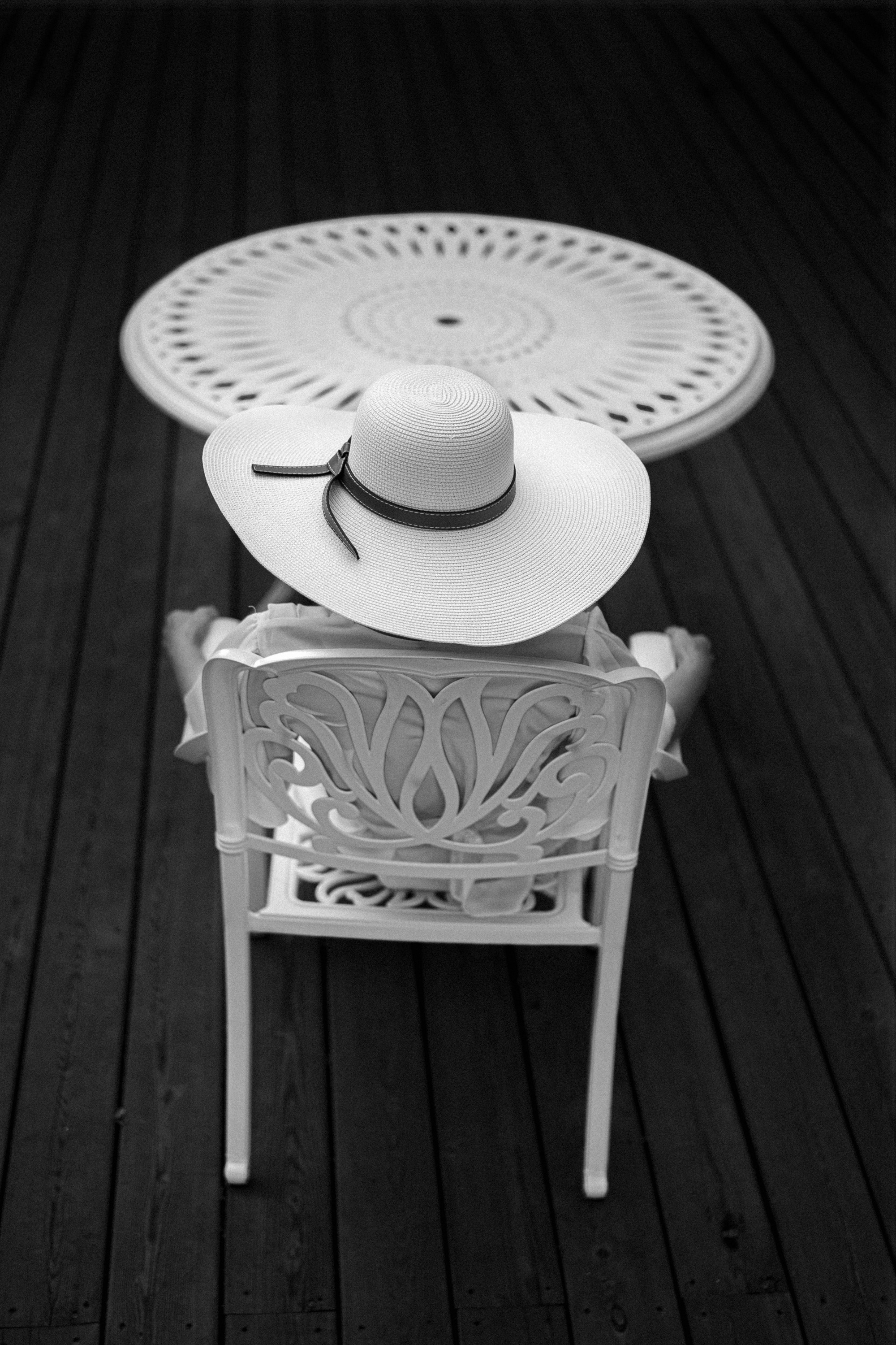 Девушка в шляпе сидит за столом.