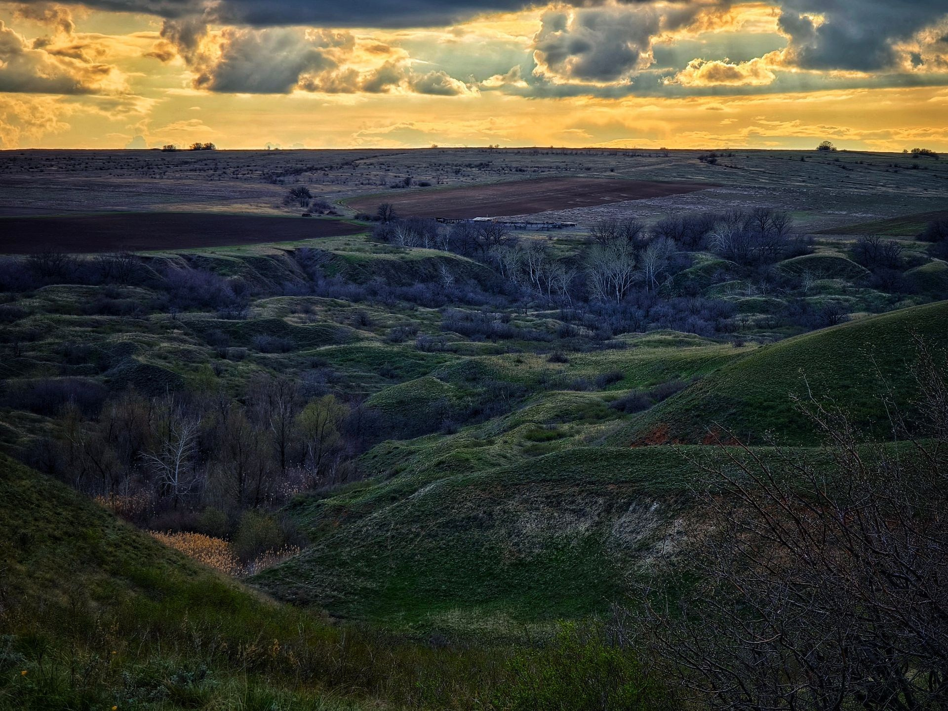 Степной пейзаж с холмами, облаками и закатным небом