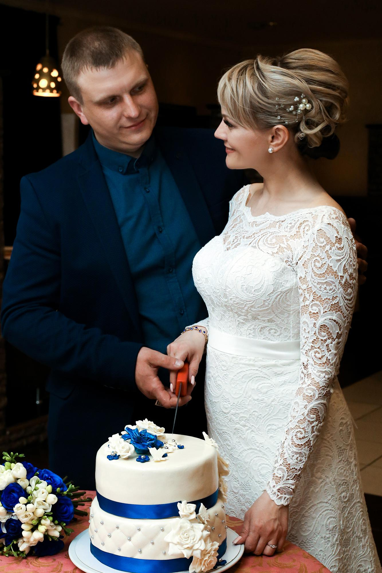 жених и невеста разрезают свадебный торт в грузинском ресторане