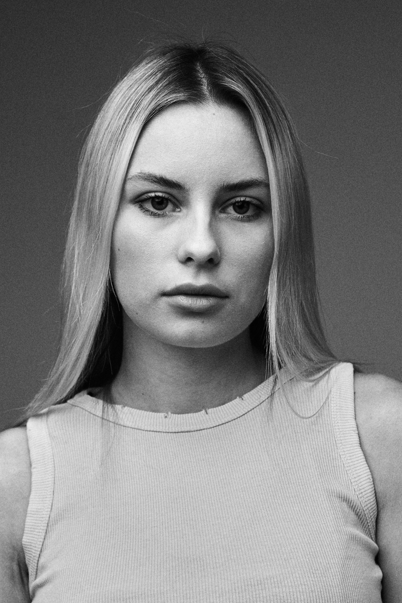 Женский полупортрет на светлом фоне — классическая пленочная фотосессия студийного типа.