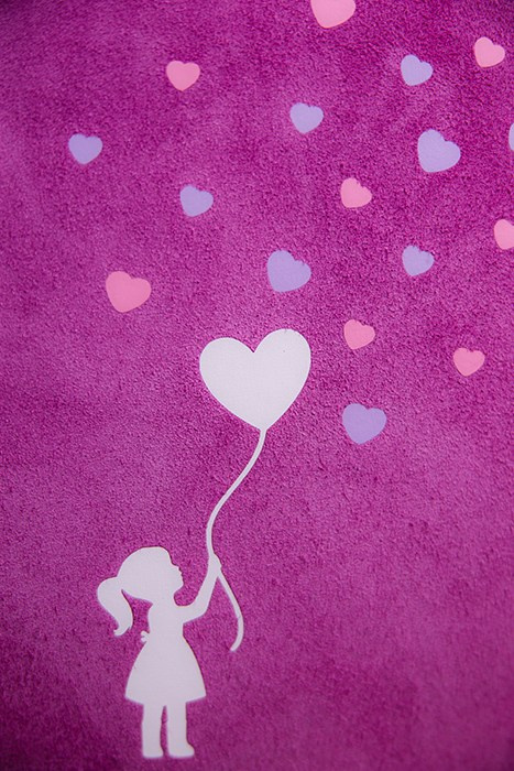 Макросъемка обложки из розовой замши с декором в виде маленьких сердечек сиреневого и розового цвета.