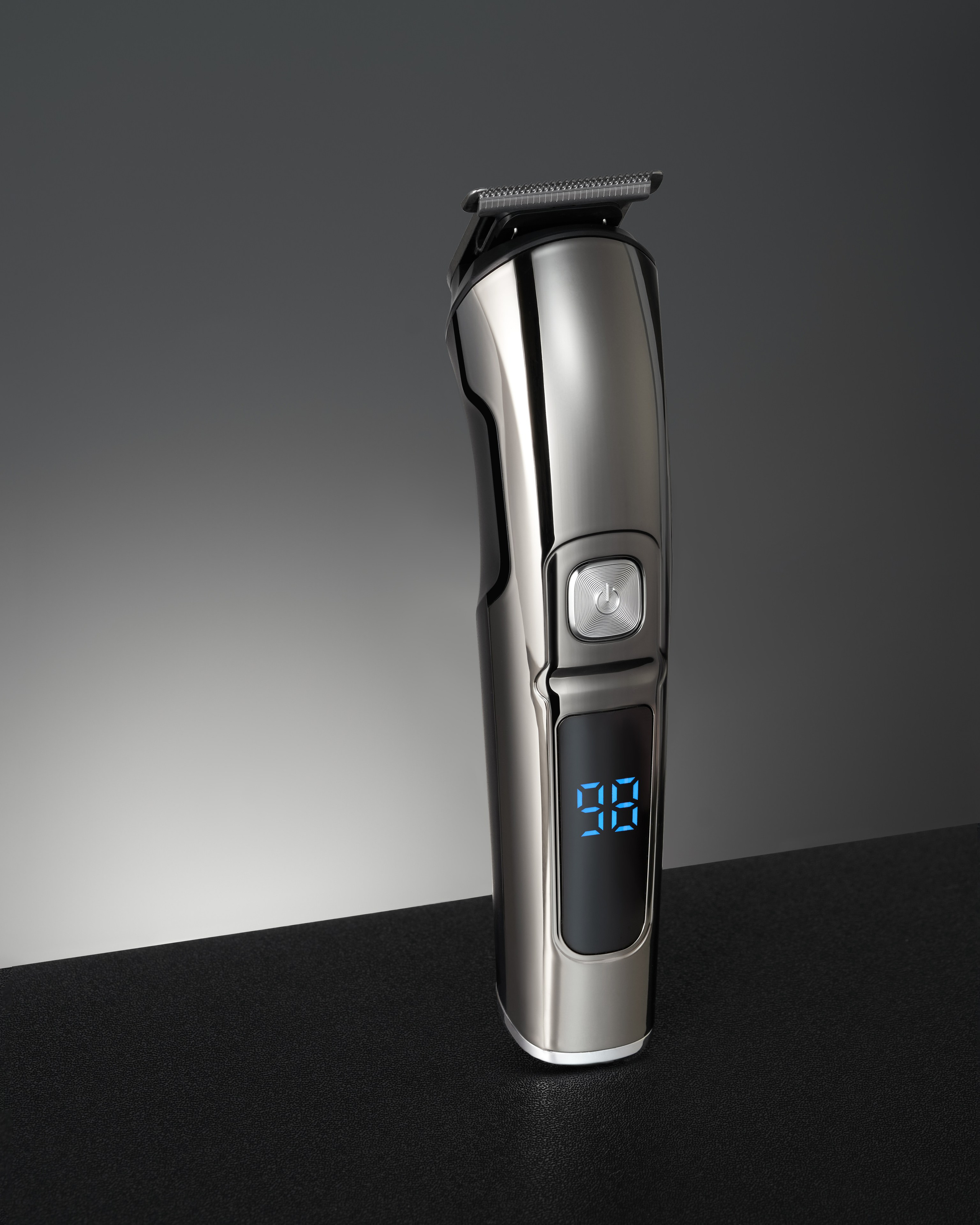 Триммер с включенным табло стоит вертикально на черном фоне