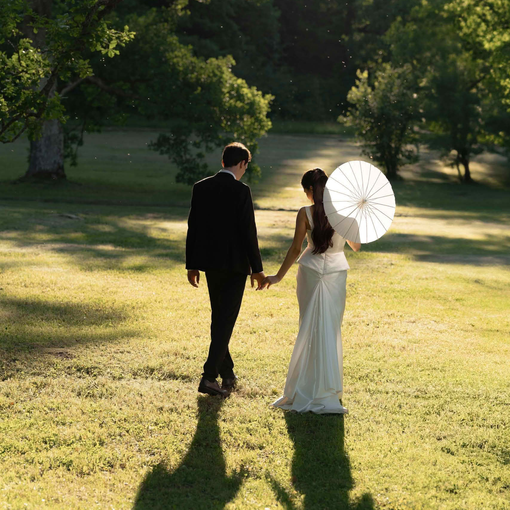 Прогулка в парке Ораниенбаум, пара идёт по солнечной поляне с бумажным зонтом