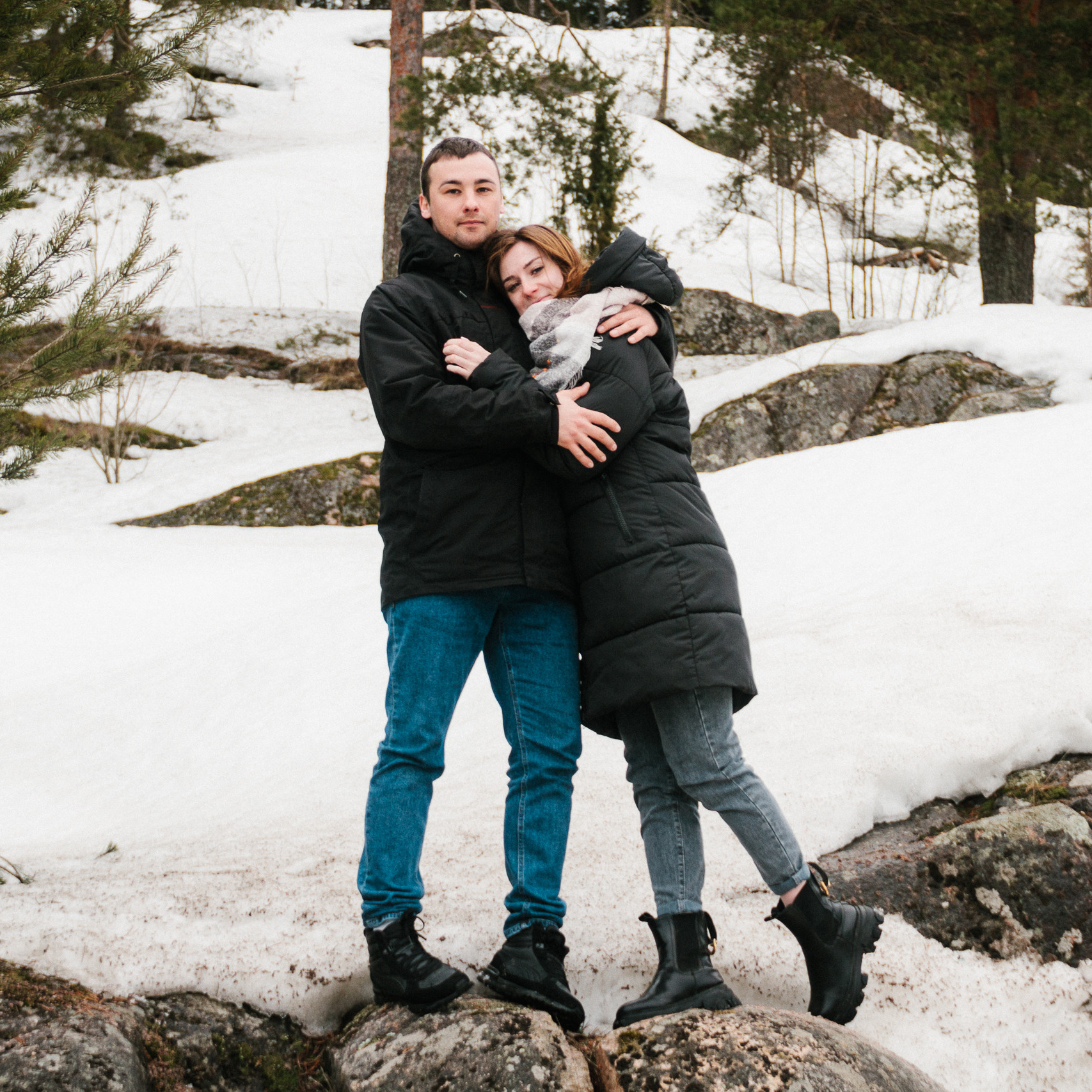 Влюбленная пара обнимается на скале в Карелии