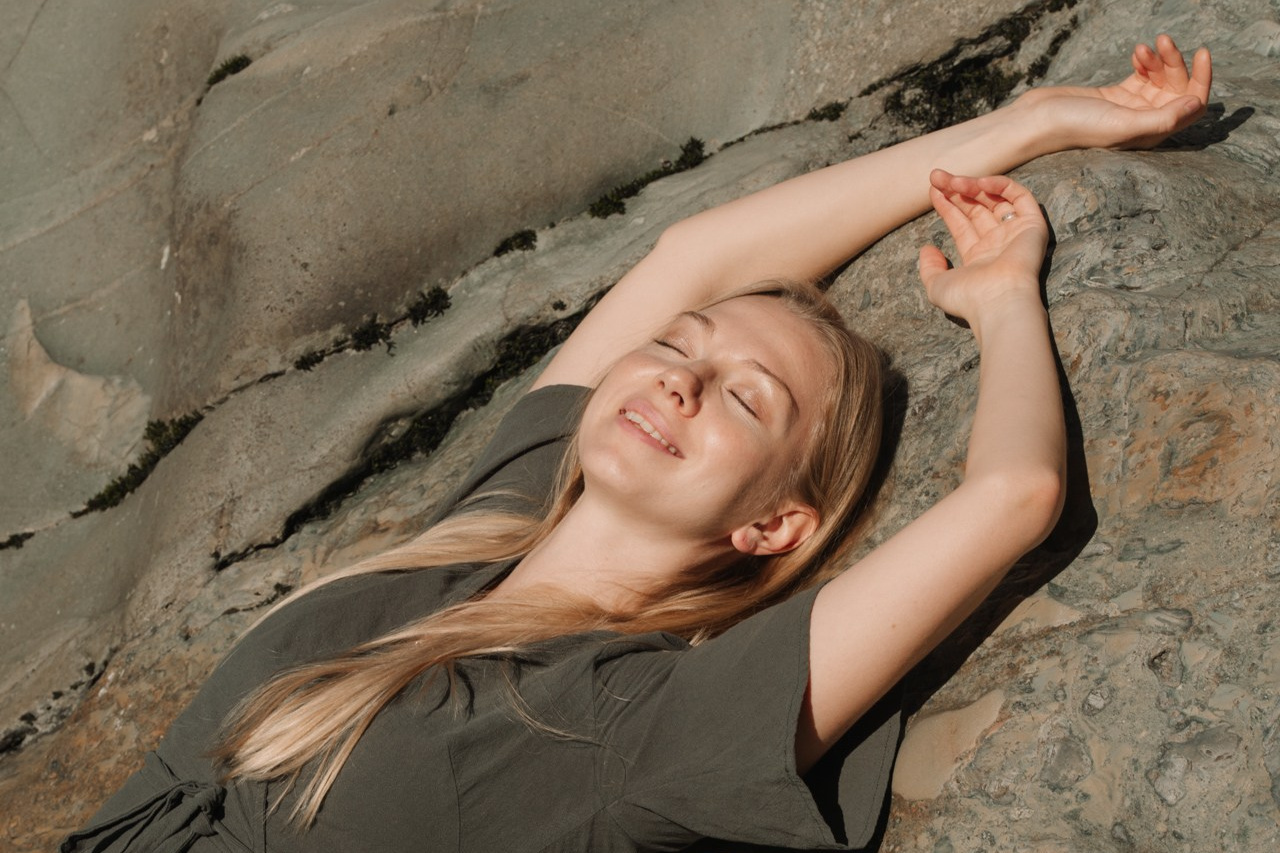 Портретная фото девушки лежащей на камне